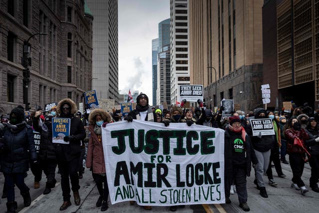 <p>Demonstrators march behind a banner reading “Justice for Amir Locke and All Stolen Lives” during a rally in protest of the killing of Amir Locke, outside the Hennepin County Government Center in Minneapolis, Minnesota on February 5, 2022</p>