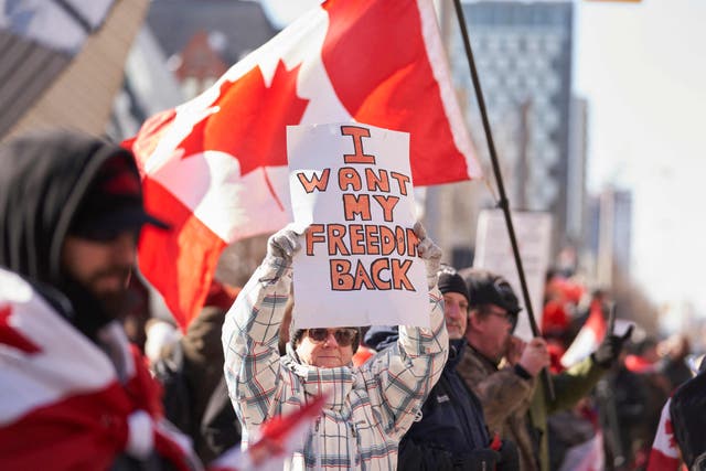 <p>A demonstrator holds a sign during a protest in downtown Toronto, Ontario, on Saturday</p>