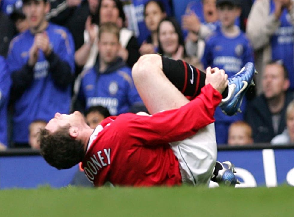 Wayne Rooney writhes around in pain at Stamford Bridge (Jane Mingay/PA)