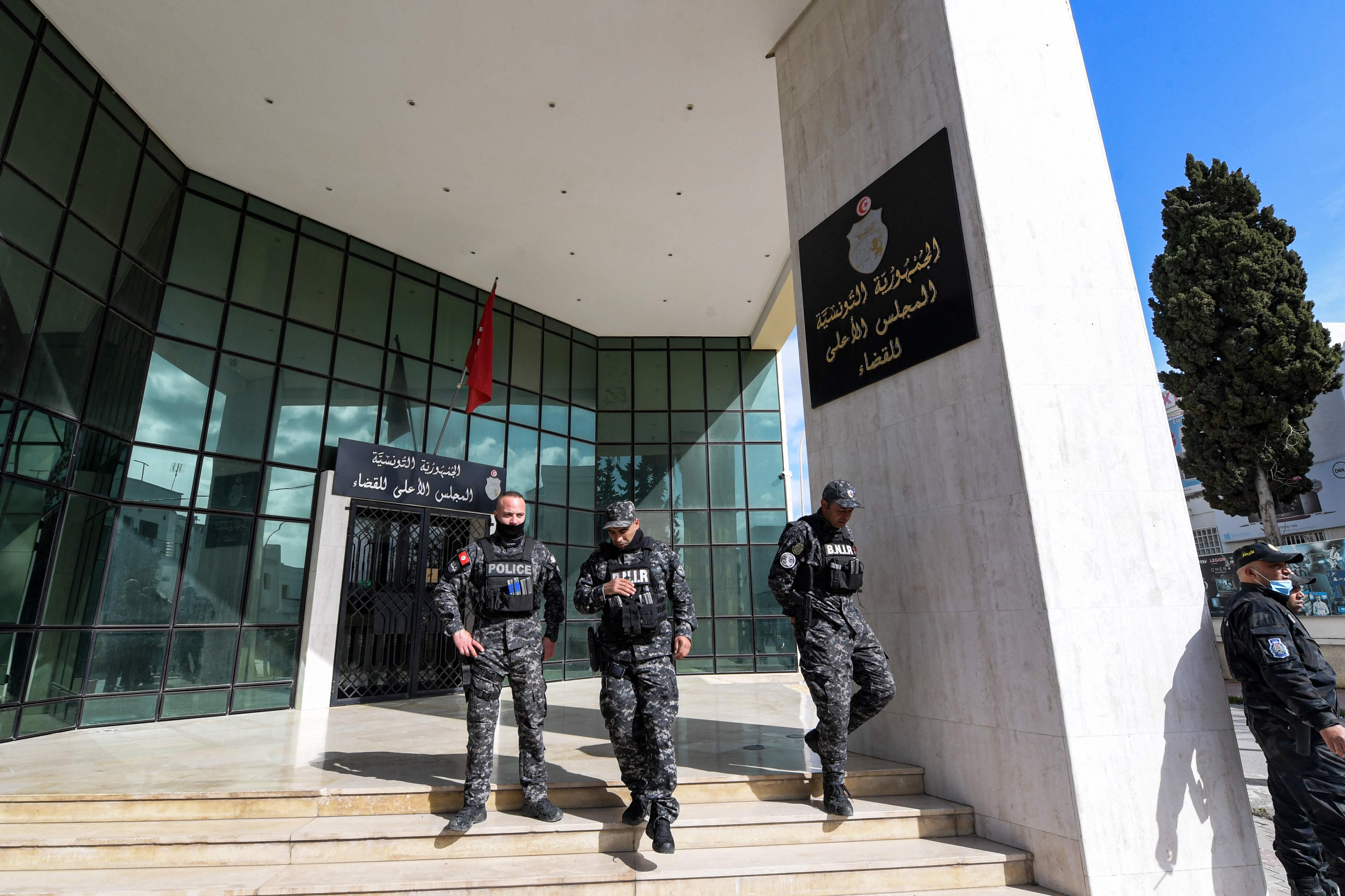 Members of the Tunisian security forces stand outside the closed entrance to the headquarters of Tunisia’s Supreme Judicial Council (CSM) in the capital Tunis on 6 February 2022
