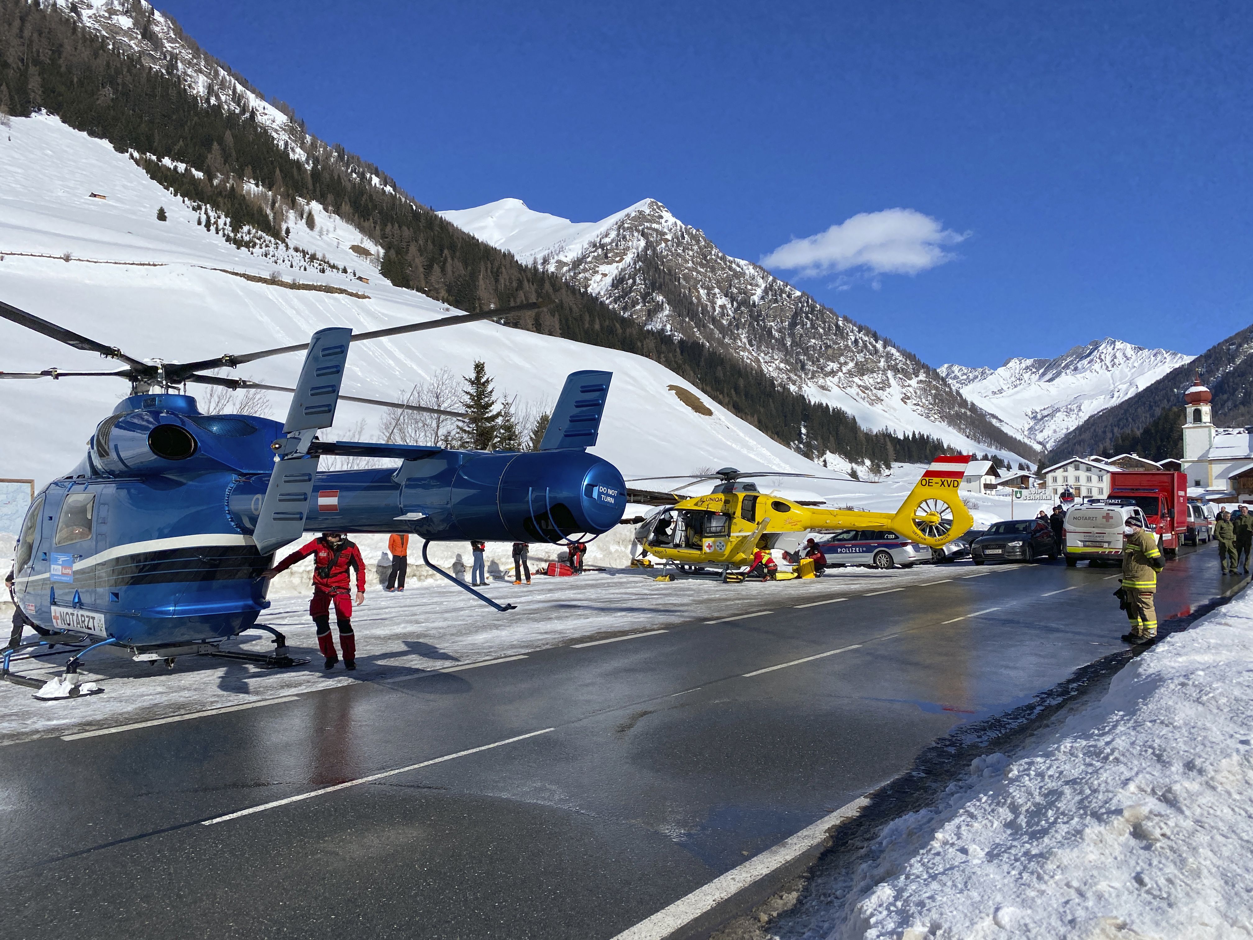 Rescue helicopters stand on a street near the Gammerspitze after an avalanche killed one person