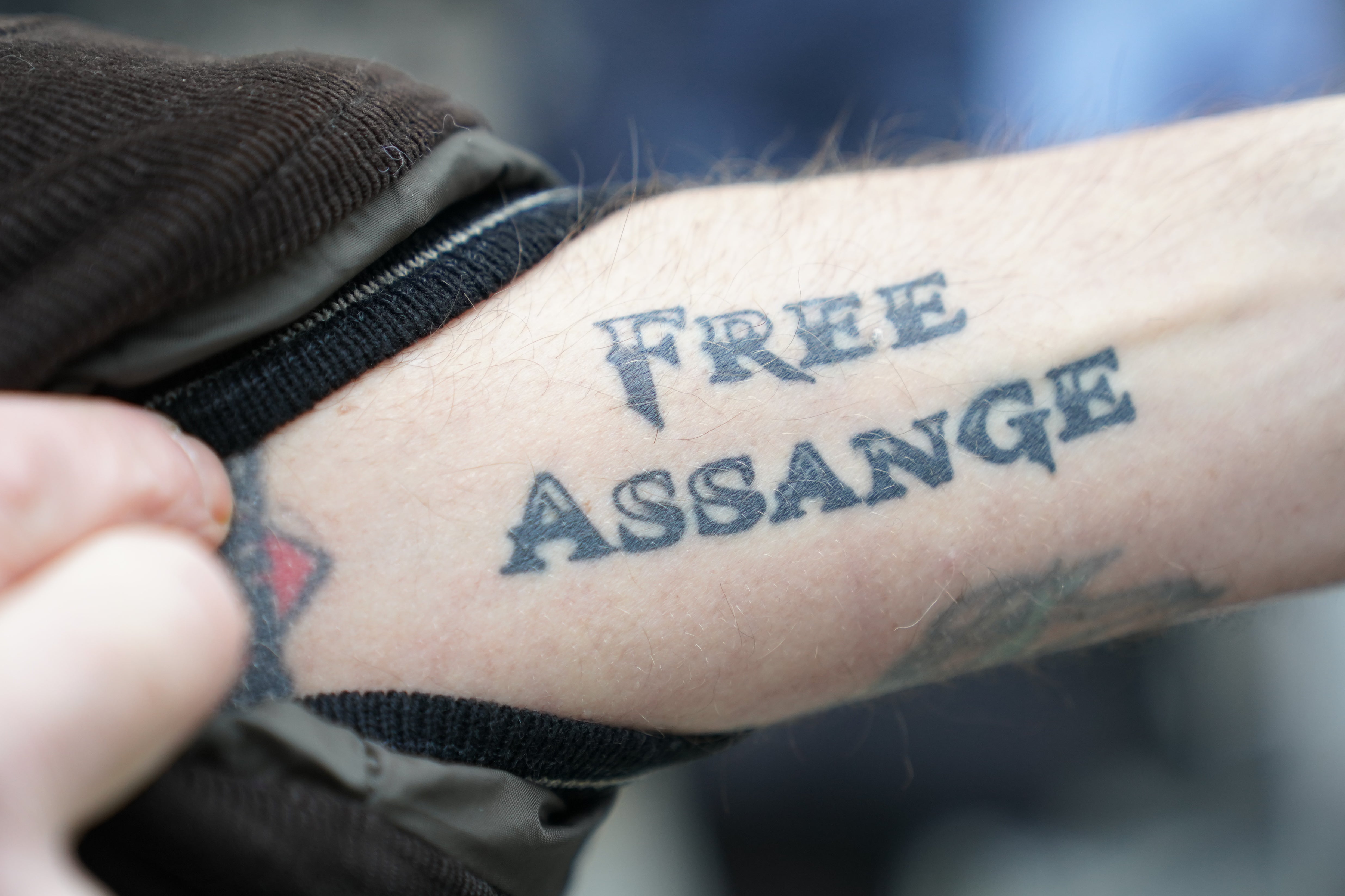 A tattoo on an arm showing Julian Assange’s name outside the Royal Courts of Justice in London (Kirsty O’Connor/PA)