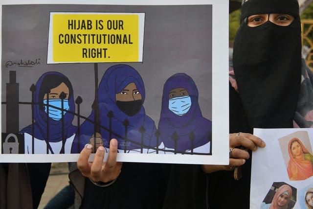 <p>A Muslim woman holds a placard reading ‘Hijab is our constitutional right’ during a demonstration after educational institutes in Karnataka denied entry to students for wearing hijabs, in Bangalore on 7 February 2022</p>