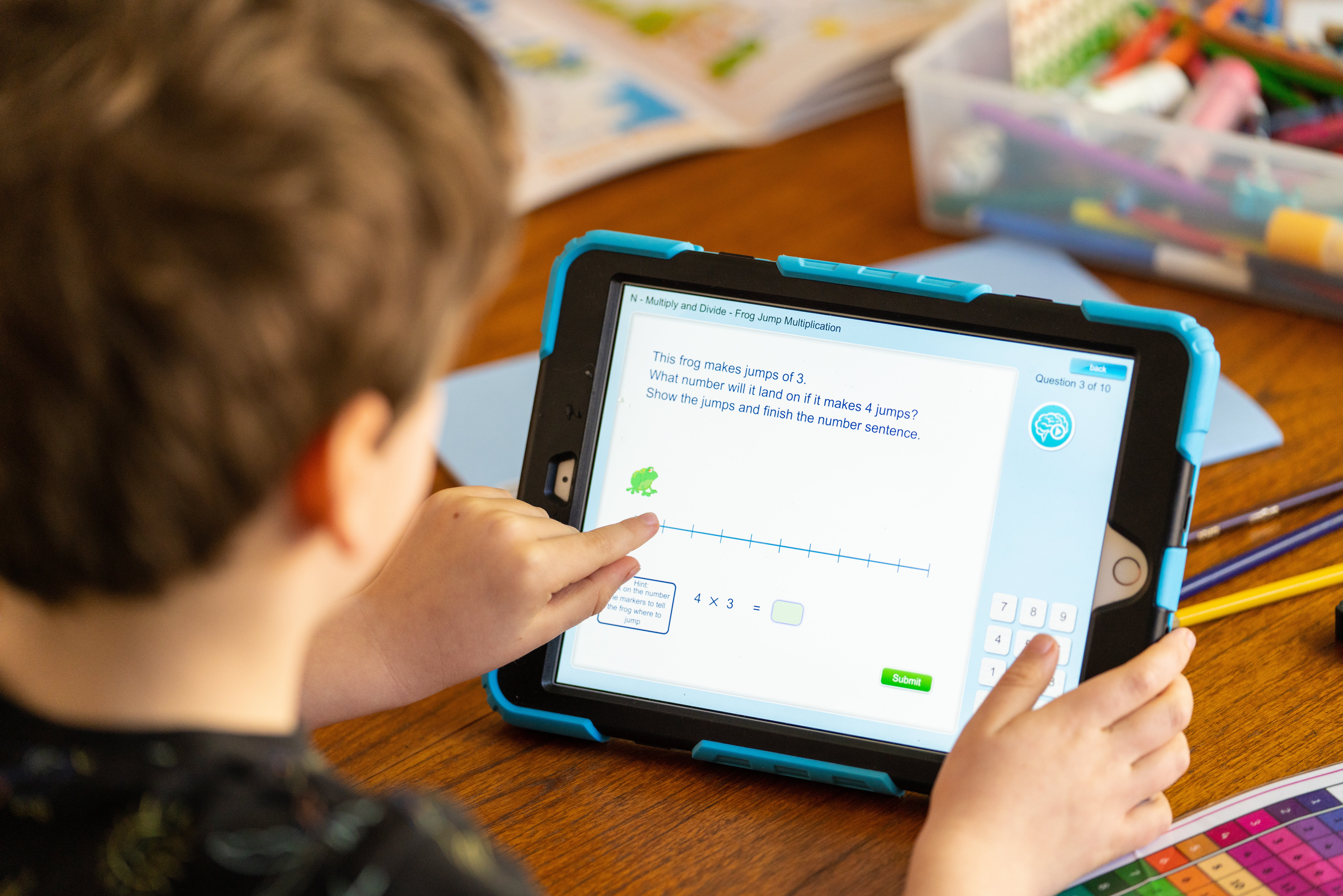 Wilfred, aged 7, does maths activities on an iPad as he takes part in home schooling (PA)