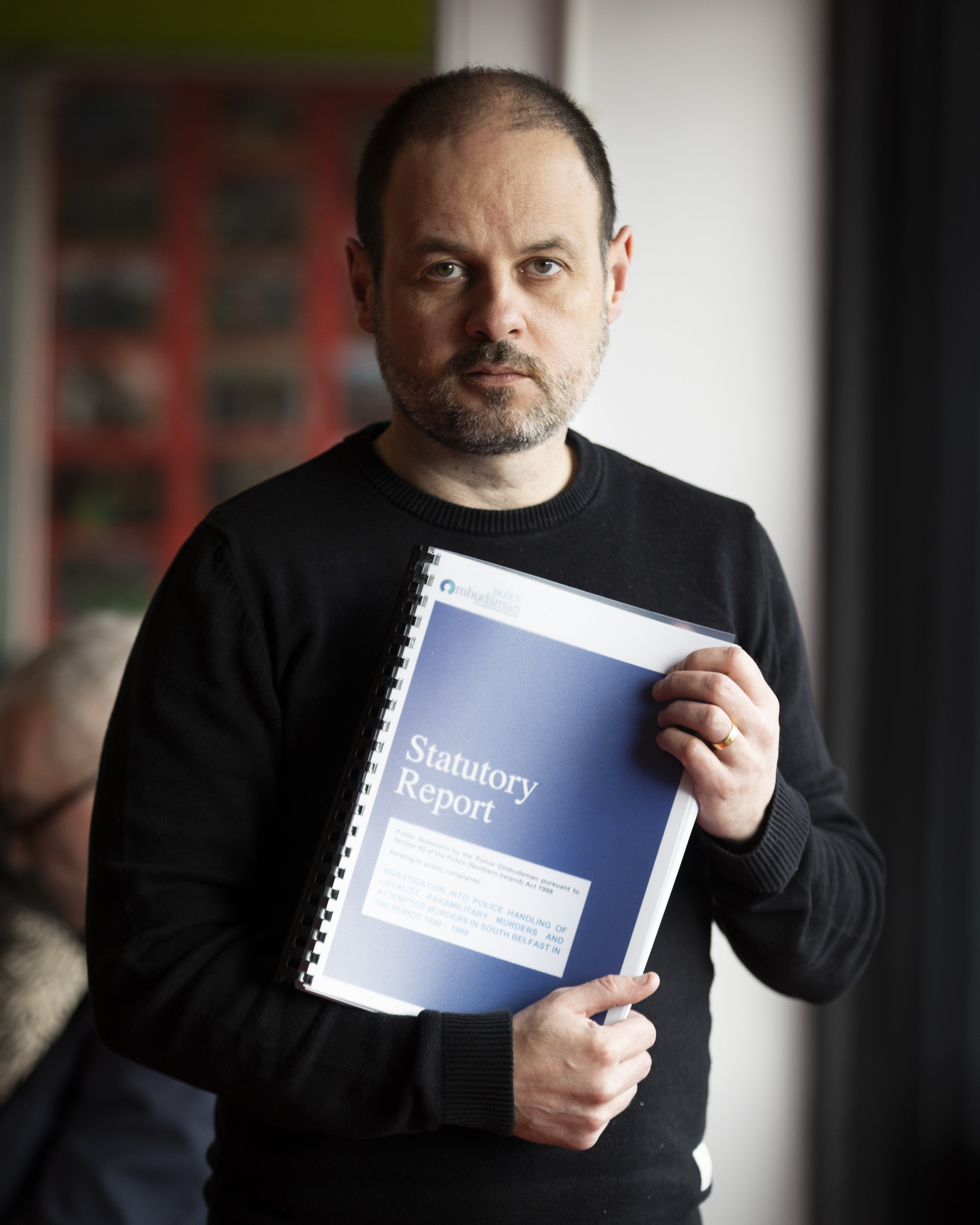 Bosco Kennedy, whose 15-year-old brother James Kennedy, was killed in the attack on Sean Graham bookmakers, holds a copy of the Police Ombudsman’s report (Liam McBurney/PA)