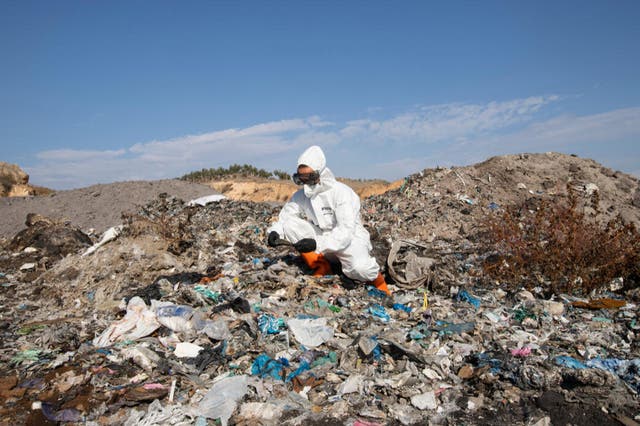 <p>A Greenpeace campaigner investigates a waste pile in Adana</p>