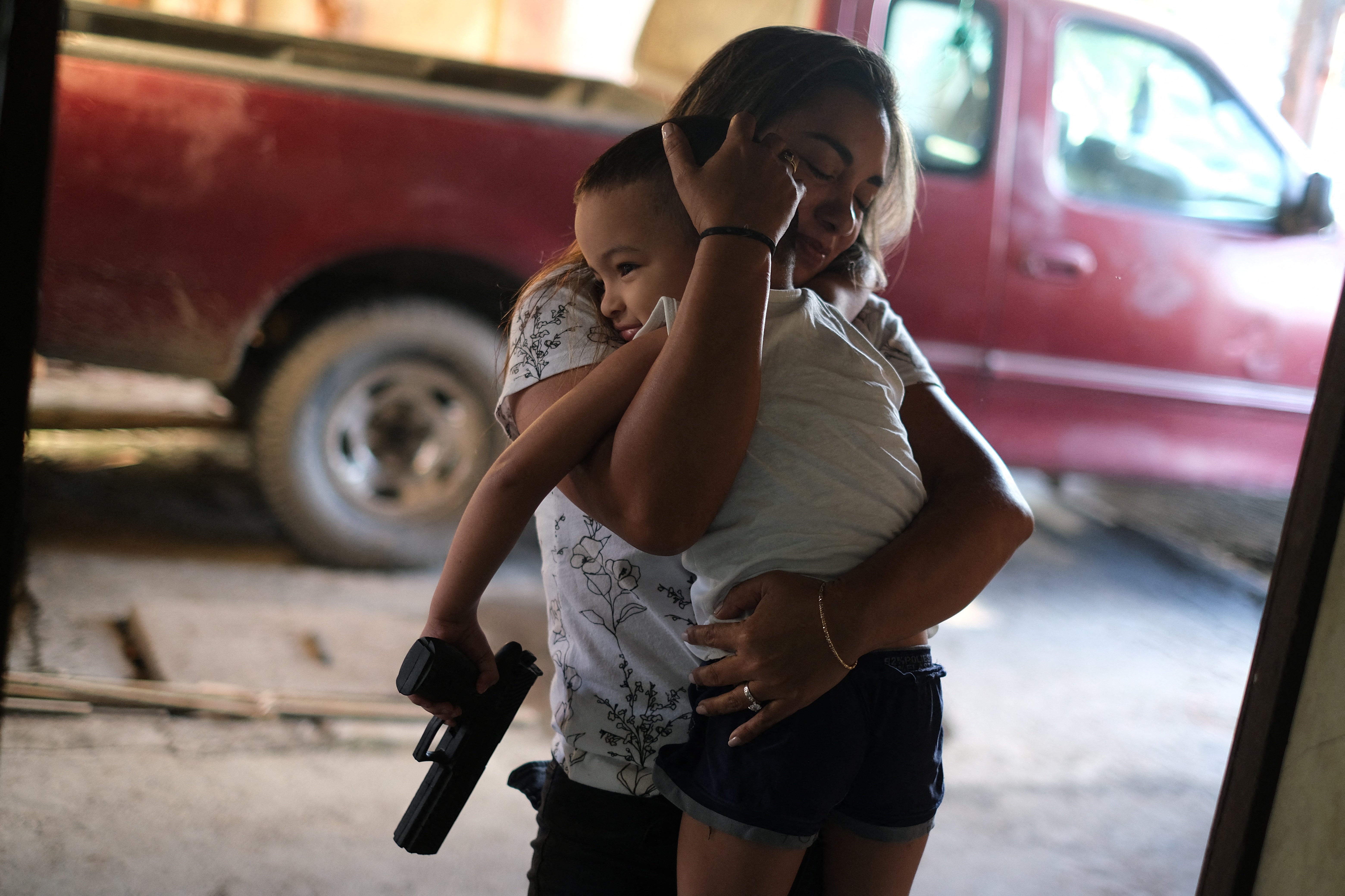 A friend of Maria embraces Hernandez’s grandson Aron as they prepare to leave their home in Honduras