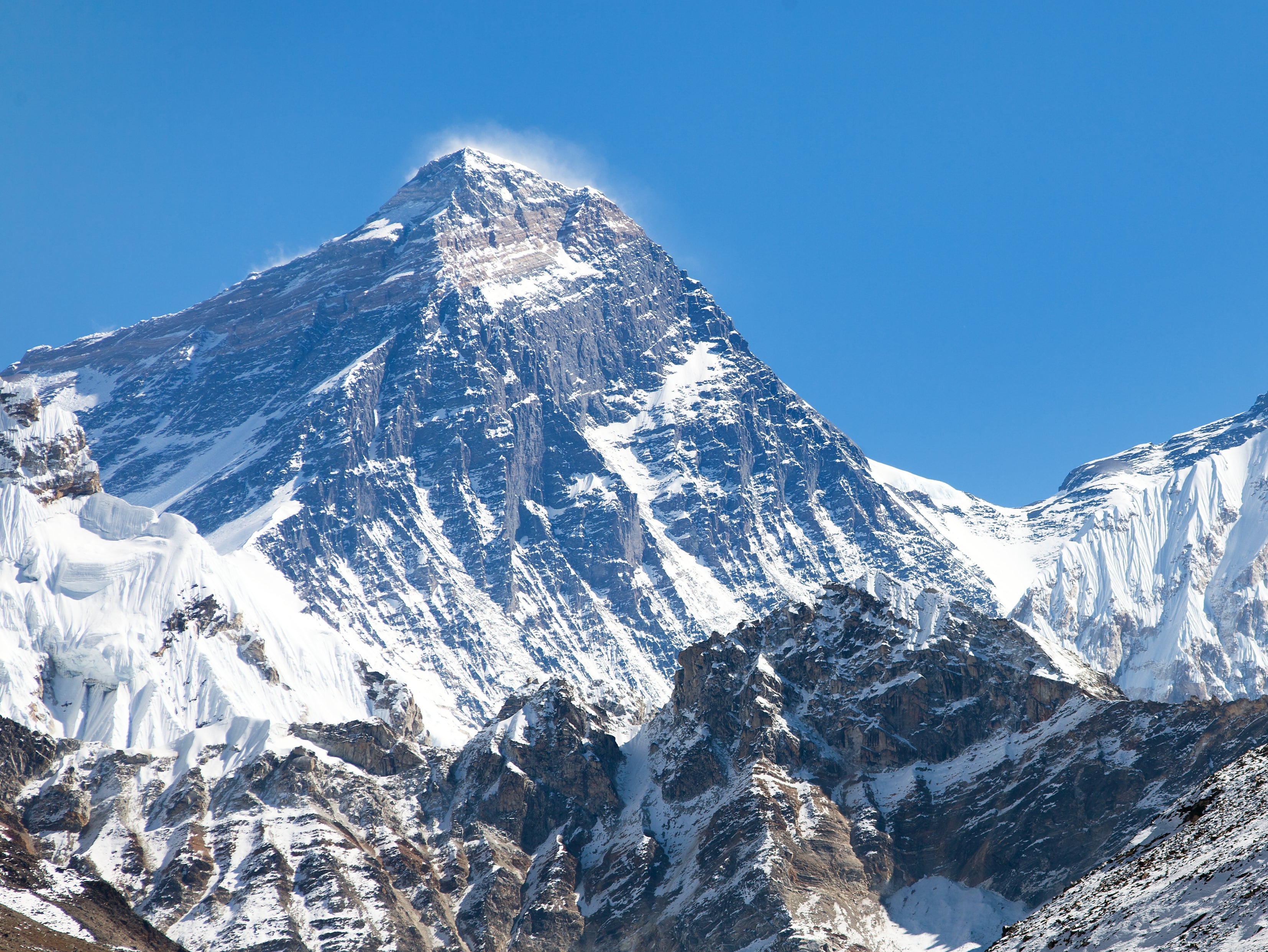 Mount Everest’s summit, the wind scoured southwest face and snowy pass of the South Col under deep blue skies in the Himalaya mountains