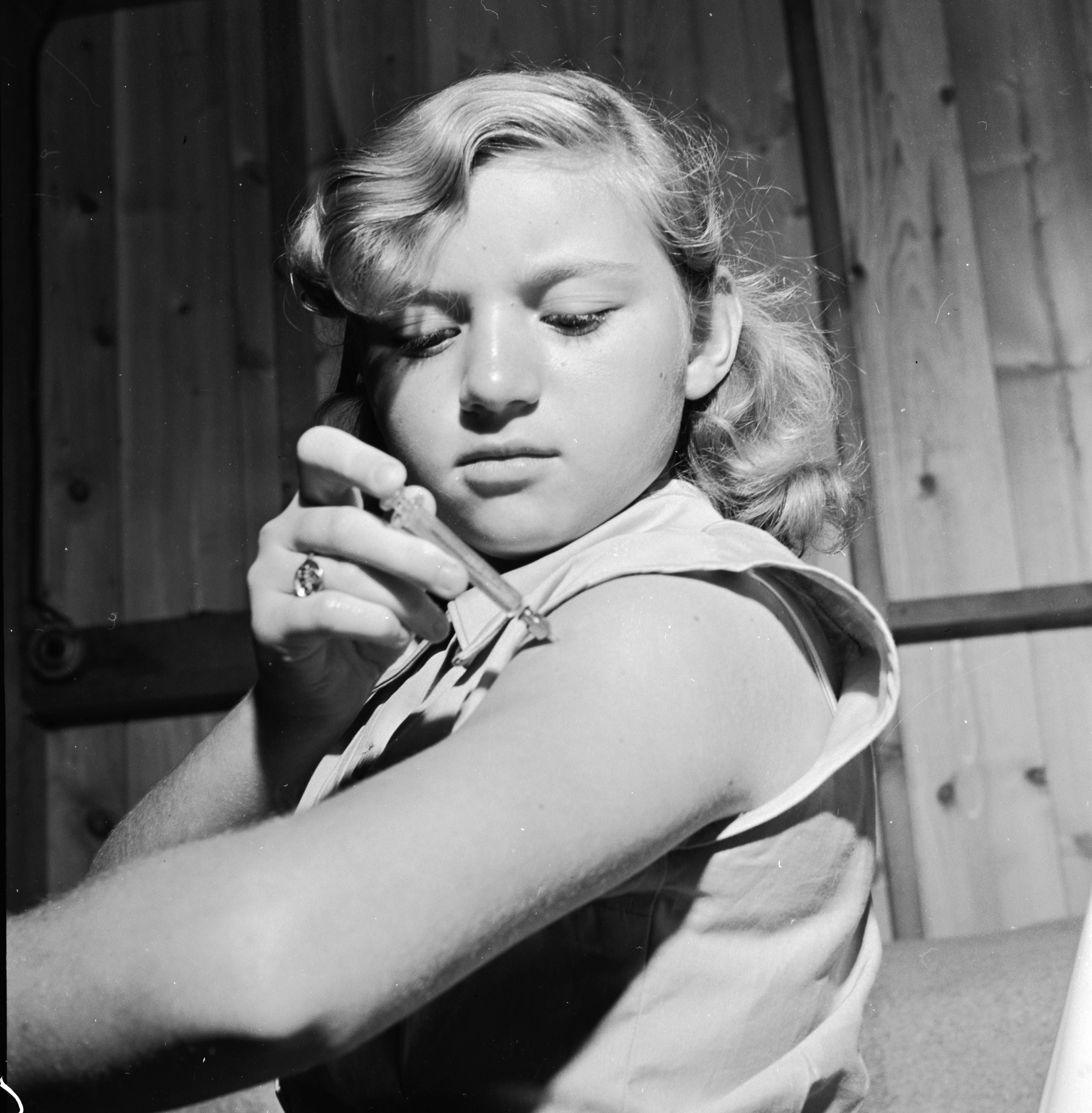 A diabetic girl injecting her arm with insulin in the 1950s