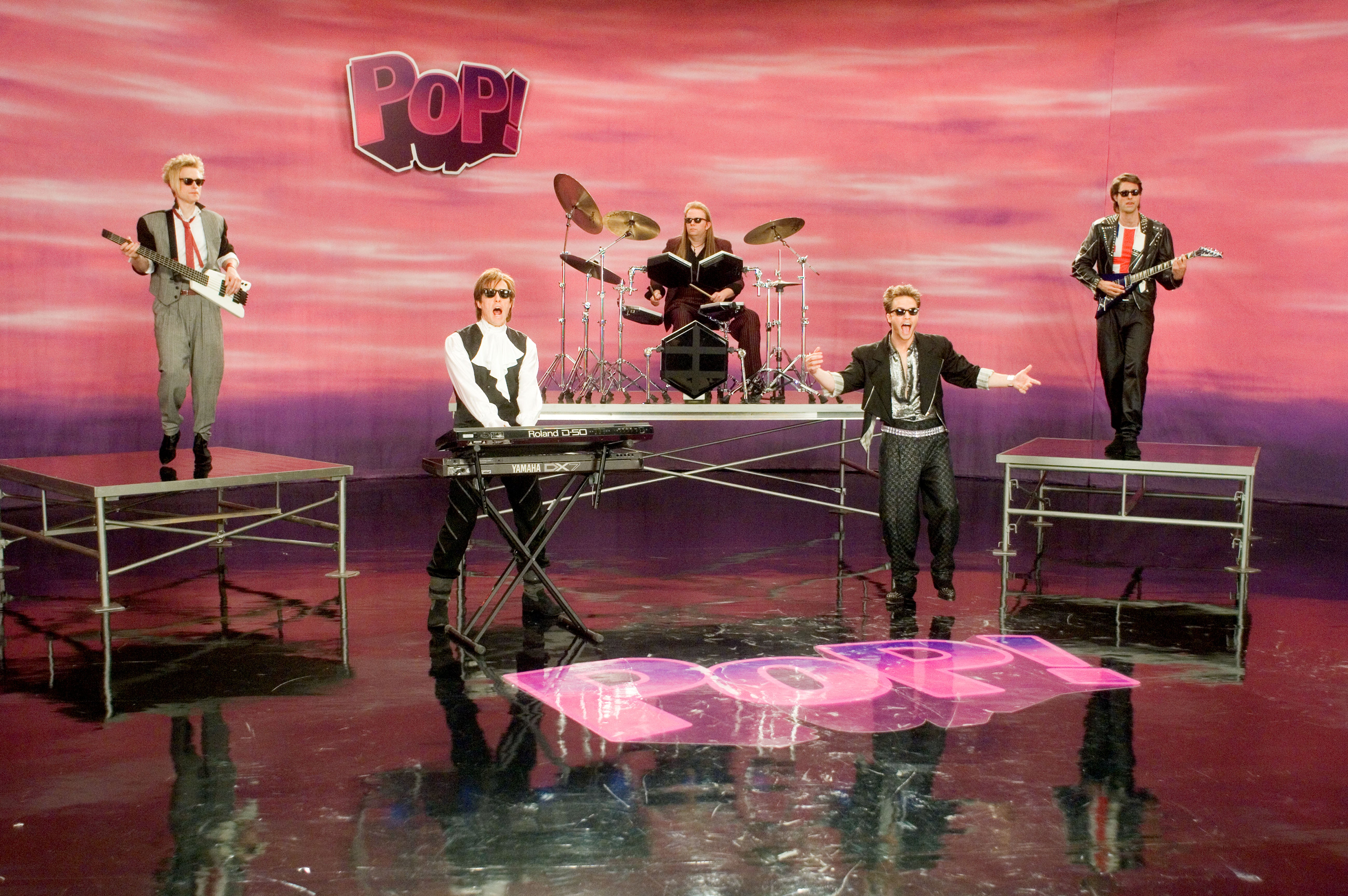 Hugh Grant (second from left) with fictional pop group PoP! in the music video for ‘Pop Goes My Heart’