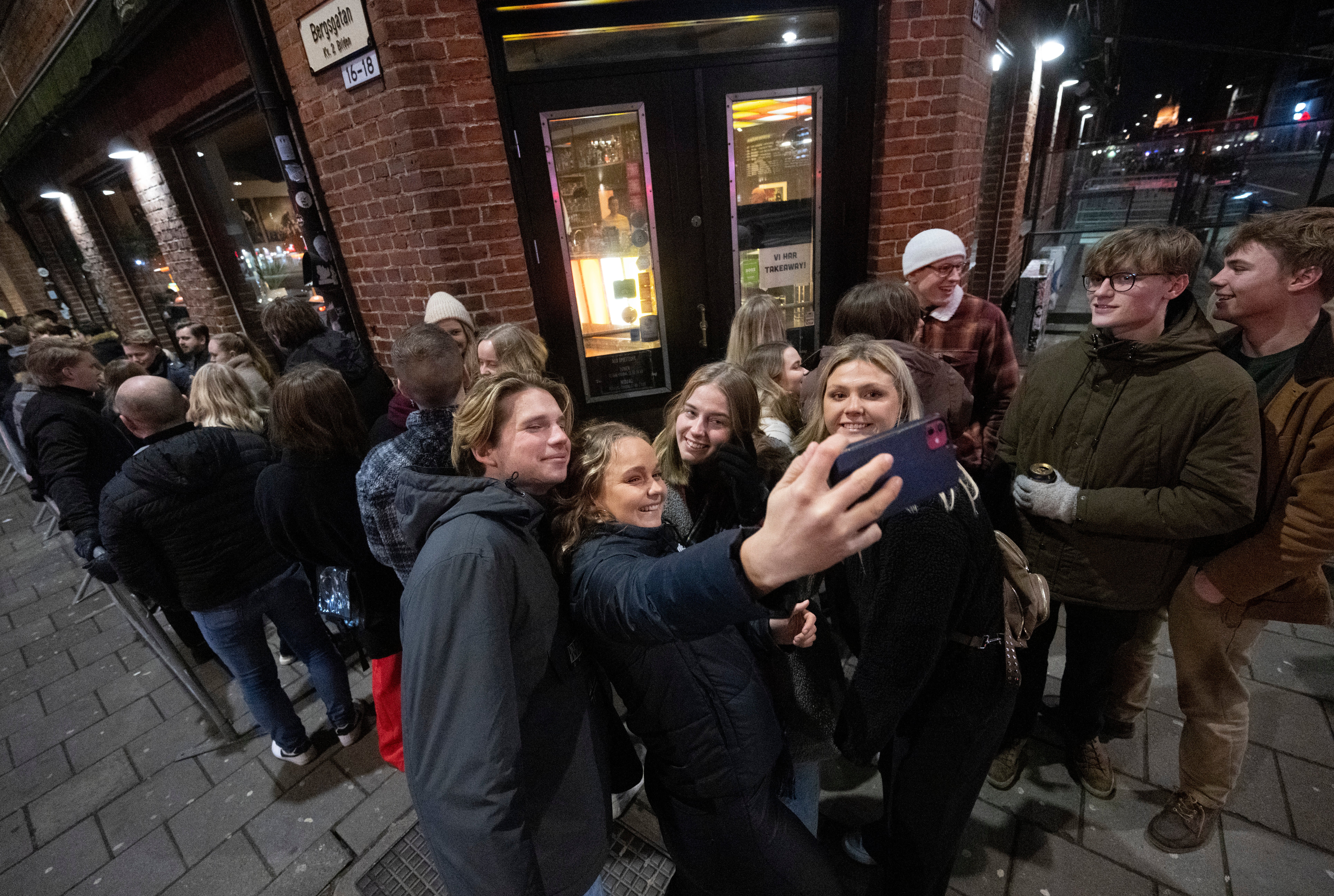 People queue outside a nightclub right after midnight in Malmo, Sweden, 9 February 2022