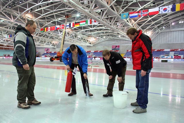 <p>Canadian Ice Master Mark Messer (2nd L) uses a fire extinguisher to repair the ice at the 2006 Olympic speedskating venue "The Oval Lingotto" as his colleagues watch during a team practise for the World Cup Speed Skating tournament in Turin December 8, 2005. REUTERS/Jerry Lampen/File Photo</p>