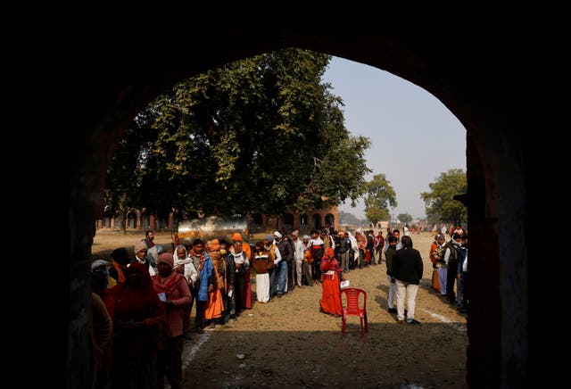 <p>People stand in a queue to cast their vote outside a polling station during the state assembly election in Vrindavan, in the northern state of Uttar Pradesh, India on 10 February 2022 </p>