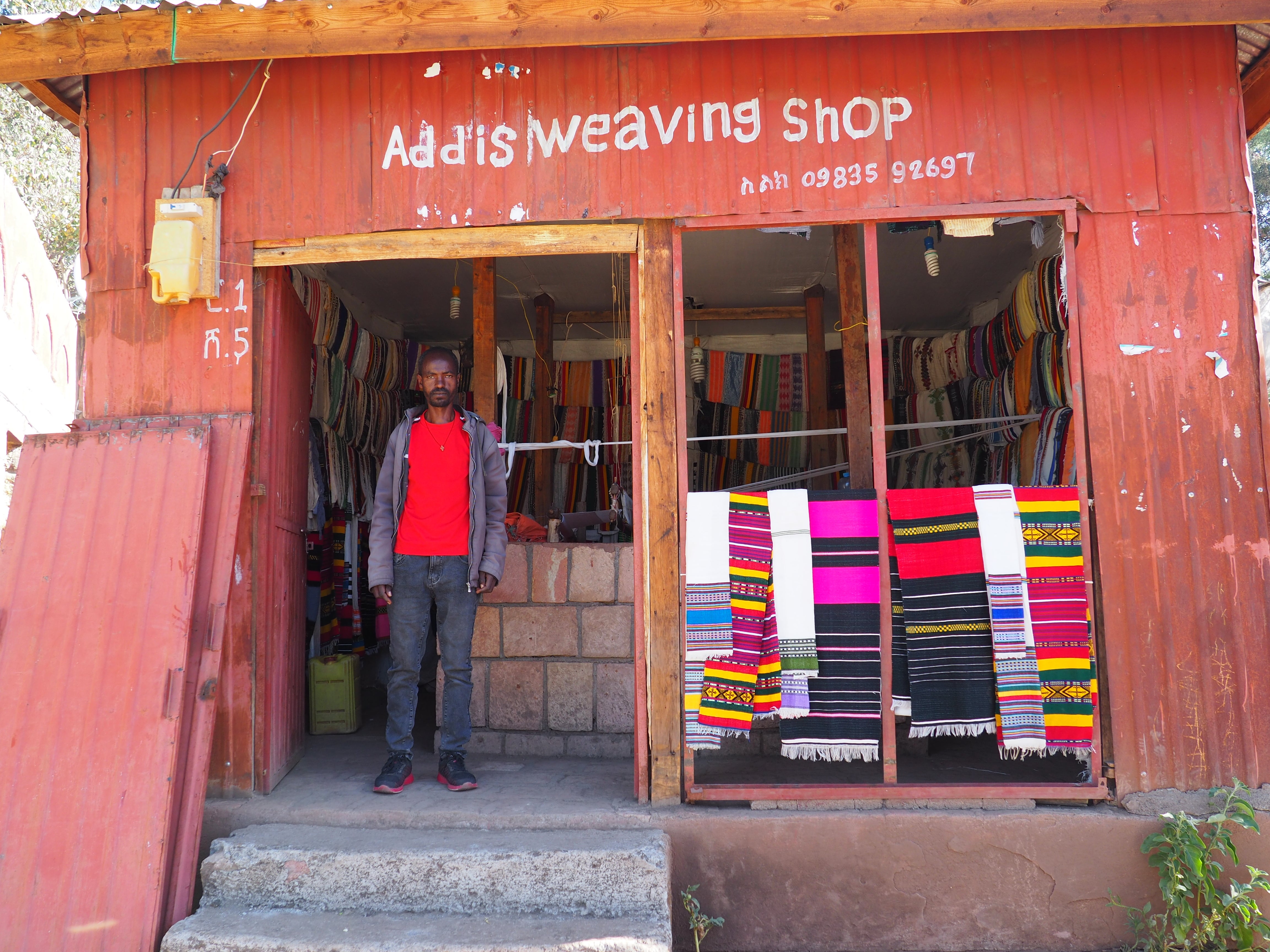 Addis Solomon stands outside his weaving shop in Lalibela, Ethiopia, 27 January 2022