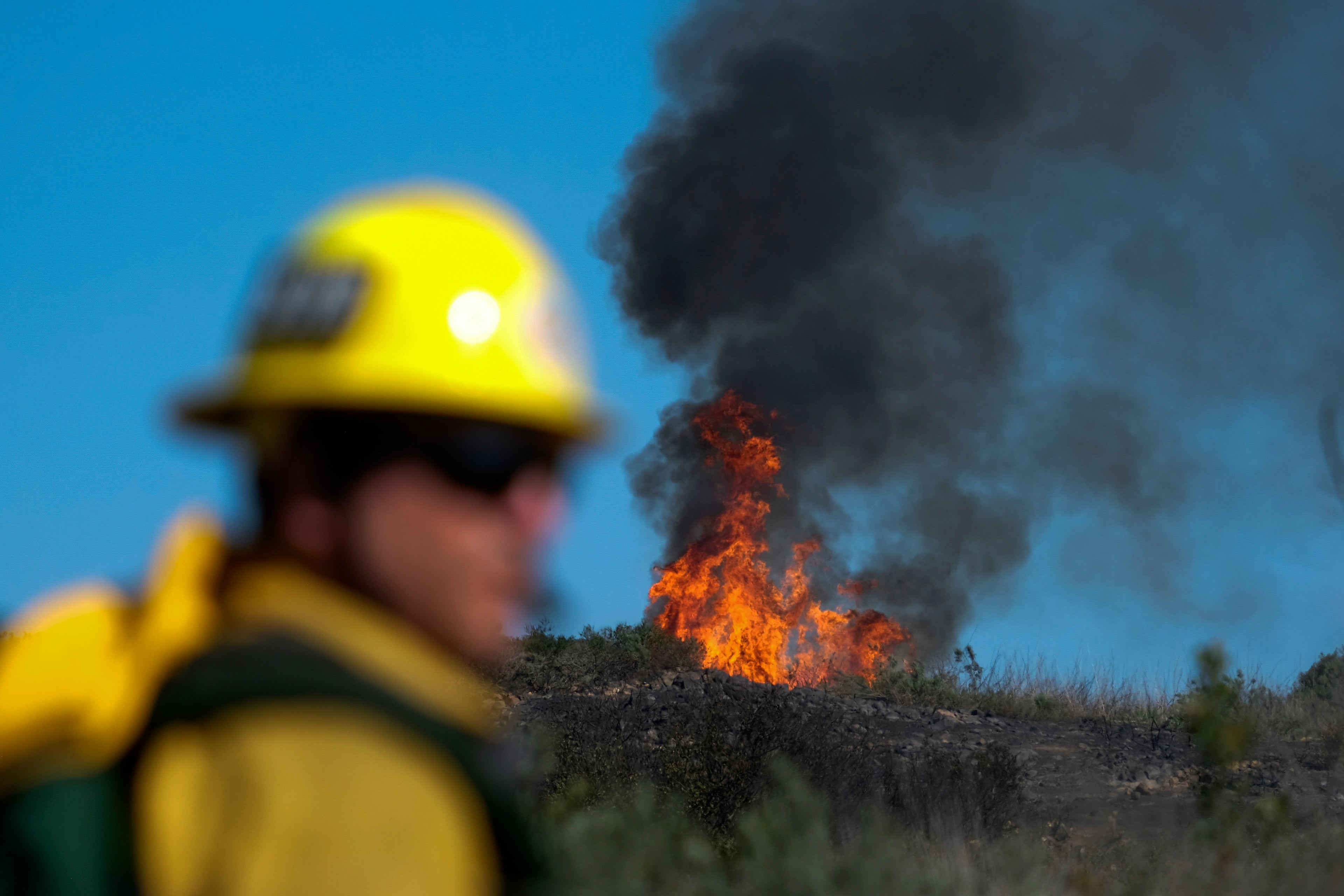 A stack of flames rise from a hillside in Laguna Beach