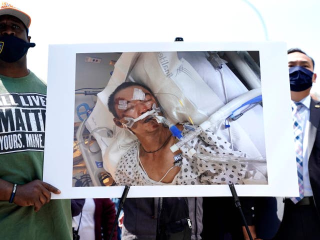 <p>People hold a photo of  61-year old Yao Pan Ma who was was attacked from behind, pushed to the ground, and repeatedly kicked in Harlem</p>