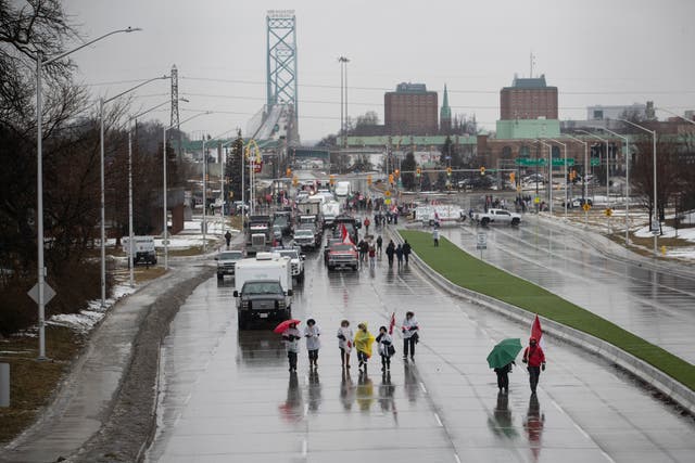 <p>Protesters and supporters attend a blockade at the foot of the Ambassador Bridge, sealing off the flow of commercial traffic over the bridge into Canada from Detroit, on February 11, 2022 in Windsor, Canada. </p>