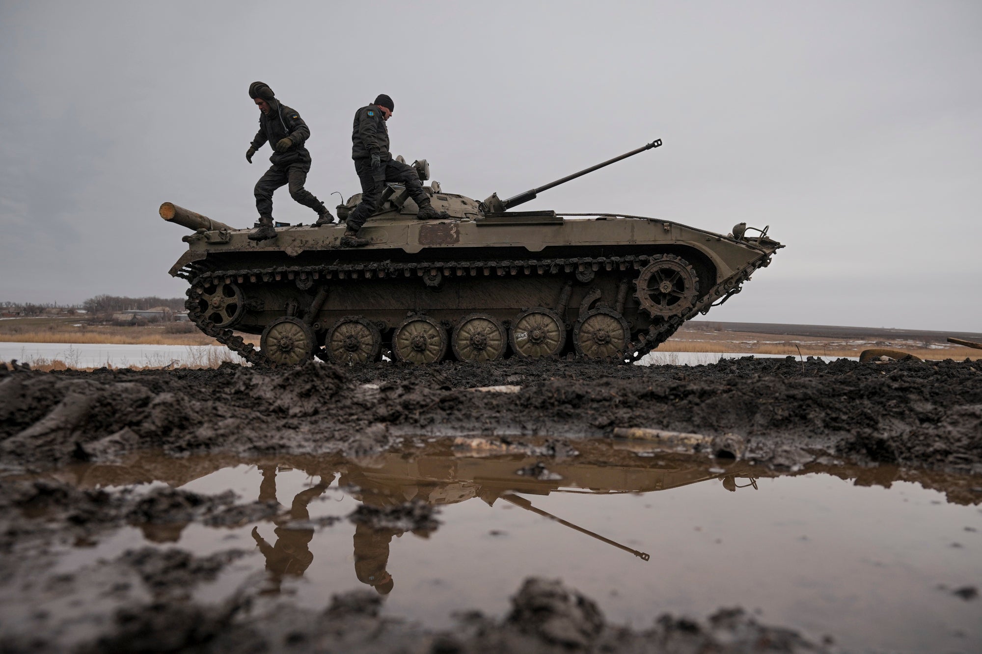 Ukrainian servicemen walk on an armoured fighting vehicle during an exercise in the controlled area in the Donetsk region (Vadim Ghirda/AP)