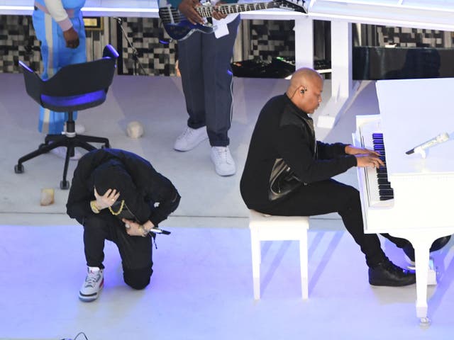 <p>Eminem kneeling during his performance with Dr Dre for the Super Bowl halftime show</p>