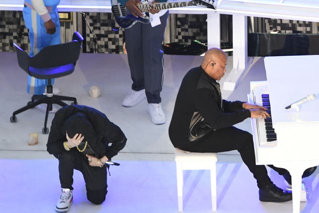 <p>Eminem kneeling during his performance with Dr Dre for the Super Bowl halftime show</p>