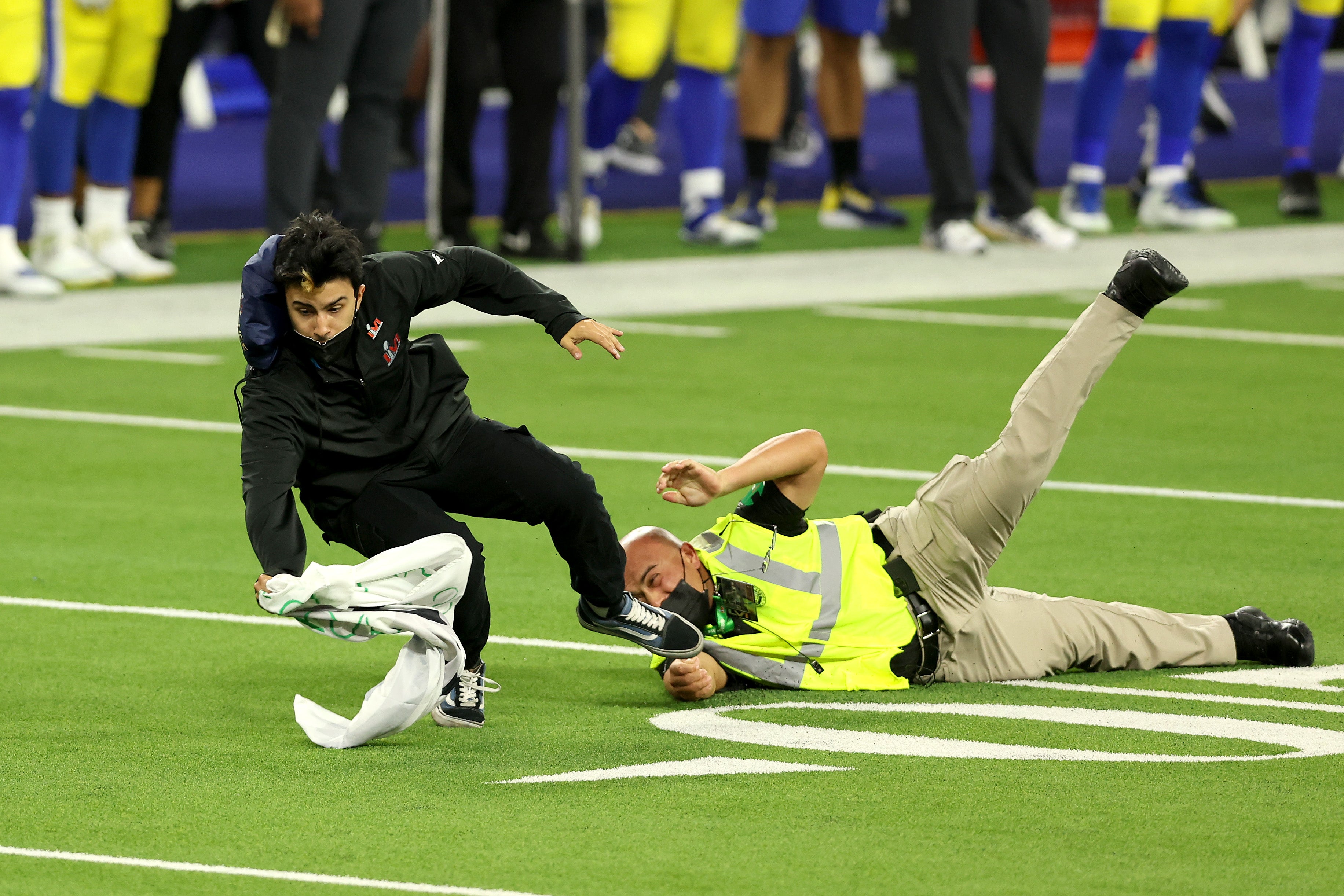 Security tackles a fan who ran on the field during Super Bowl LVI