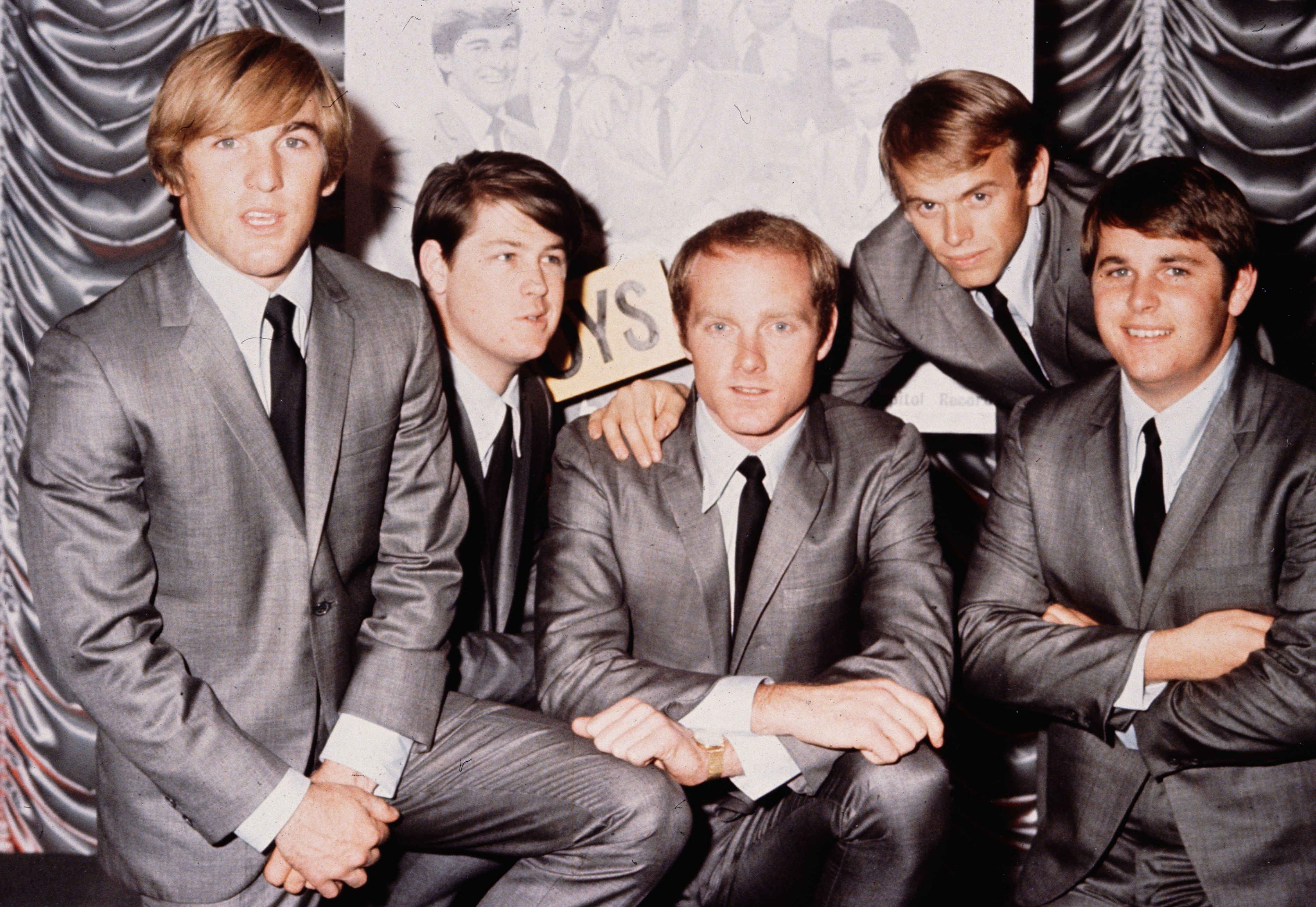 American pop group The Beach Boys pictured in 1964. Love sits centrally, with Wilson second from the left