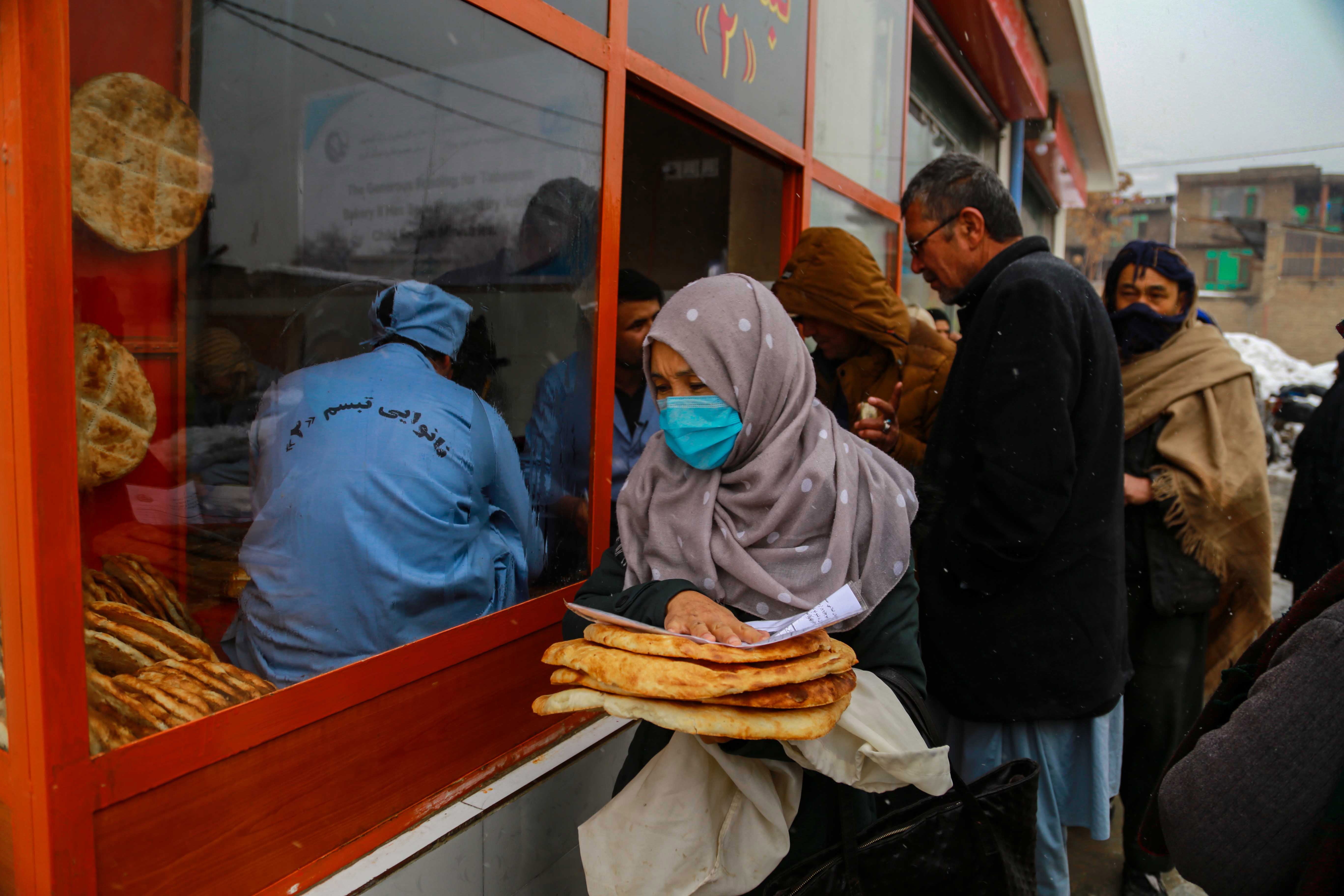 Afghans receive free bread from a charity bakery in Kabul
