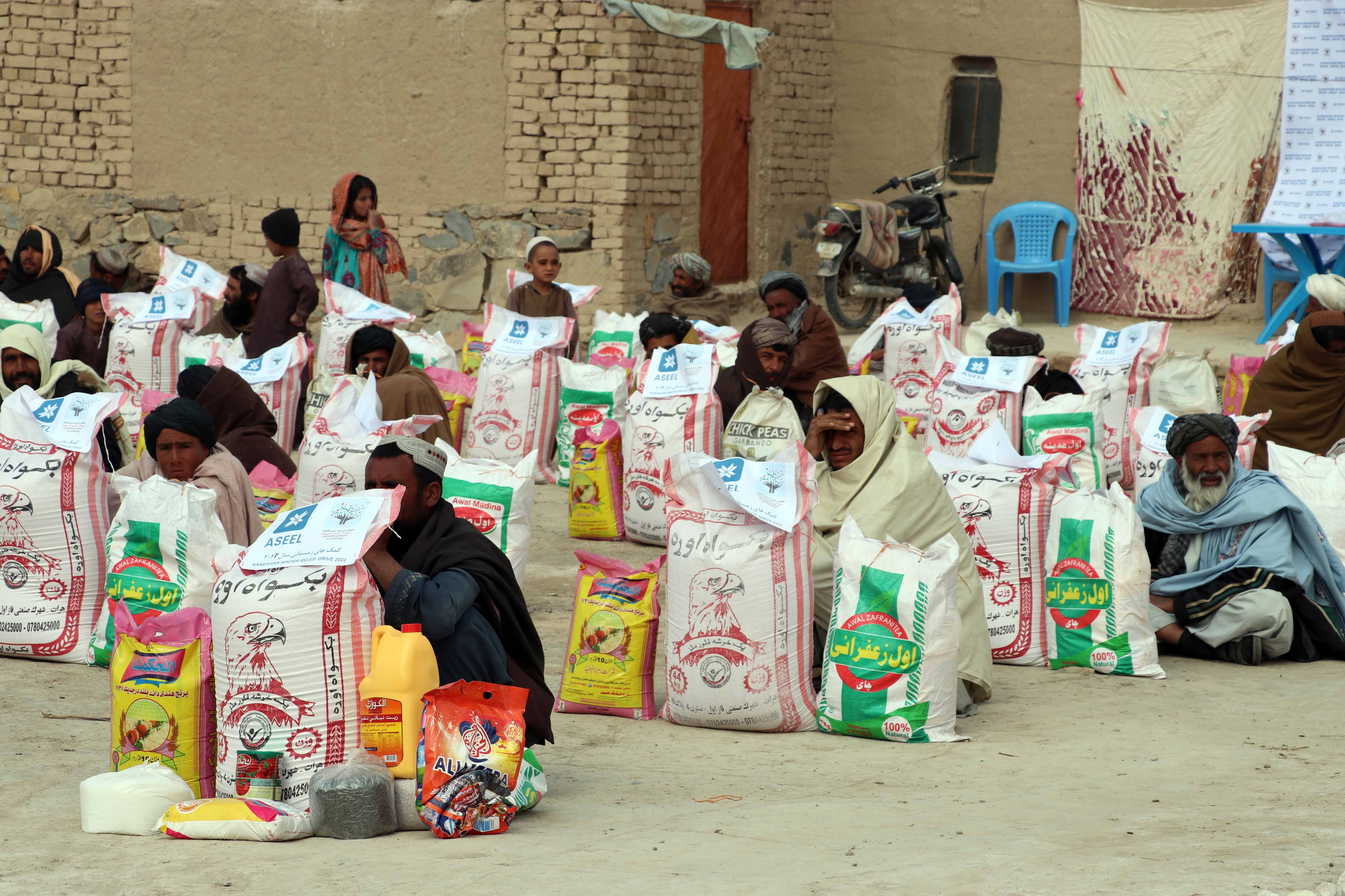 People receive food rations distributed by Afghan Charity Foundation in Kandahar