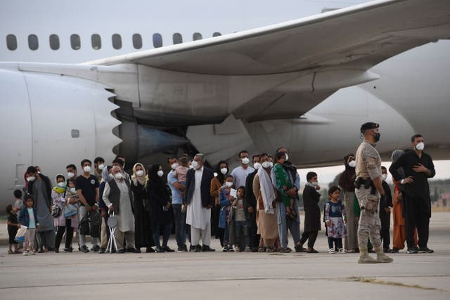 <p>Refugees queue on the tarmac after disembarking from an evacuation flight from Kabul at an air base in Spain in 2021 </p>