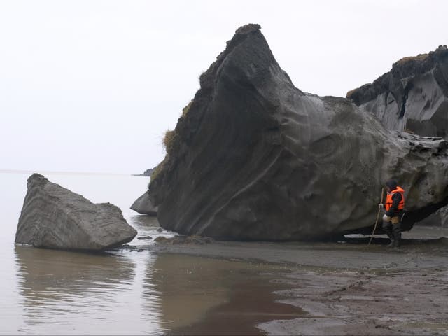 <p>Scientist investigating coastal erosion caused by thawing permafrost near Bykovsky peninsula, Laptev Sea, Siberia, Russia</p>