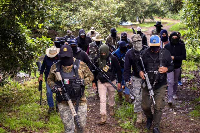<p>Members of the self-defense group Pueblos Unidos carry out guard duties in protection of avocado plantations, whipped by drug cartels that dominate the area, in Ario de Rosales, state of Michoacan, Mexico, on July 8, 2021. - (Photo by ENRIQUE CASTRO / AFP) </p>