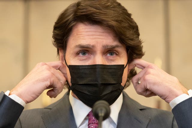<p>Canadian prime minister Justin Trudeau removes his mask as he arrives at a news conference</p>