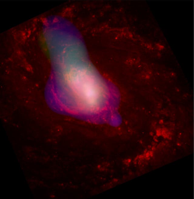 <p>A white gass cloud is blown out from the center of active galaxy Messier 77, presumably by the supermassive black hole that lurks in its core. </p>