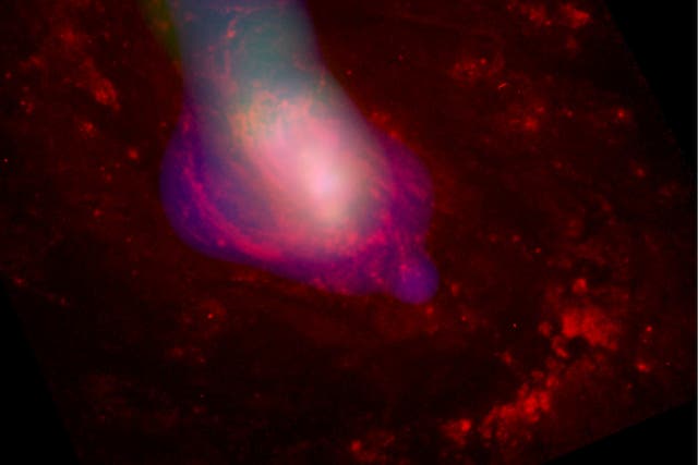 <p>A white gass cloud is blown out from the center of active galaxy Messier 77, presumably by the supermassive black hole that lurks in its core. </p>
