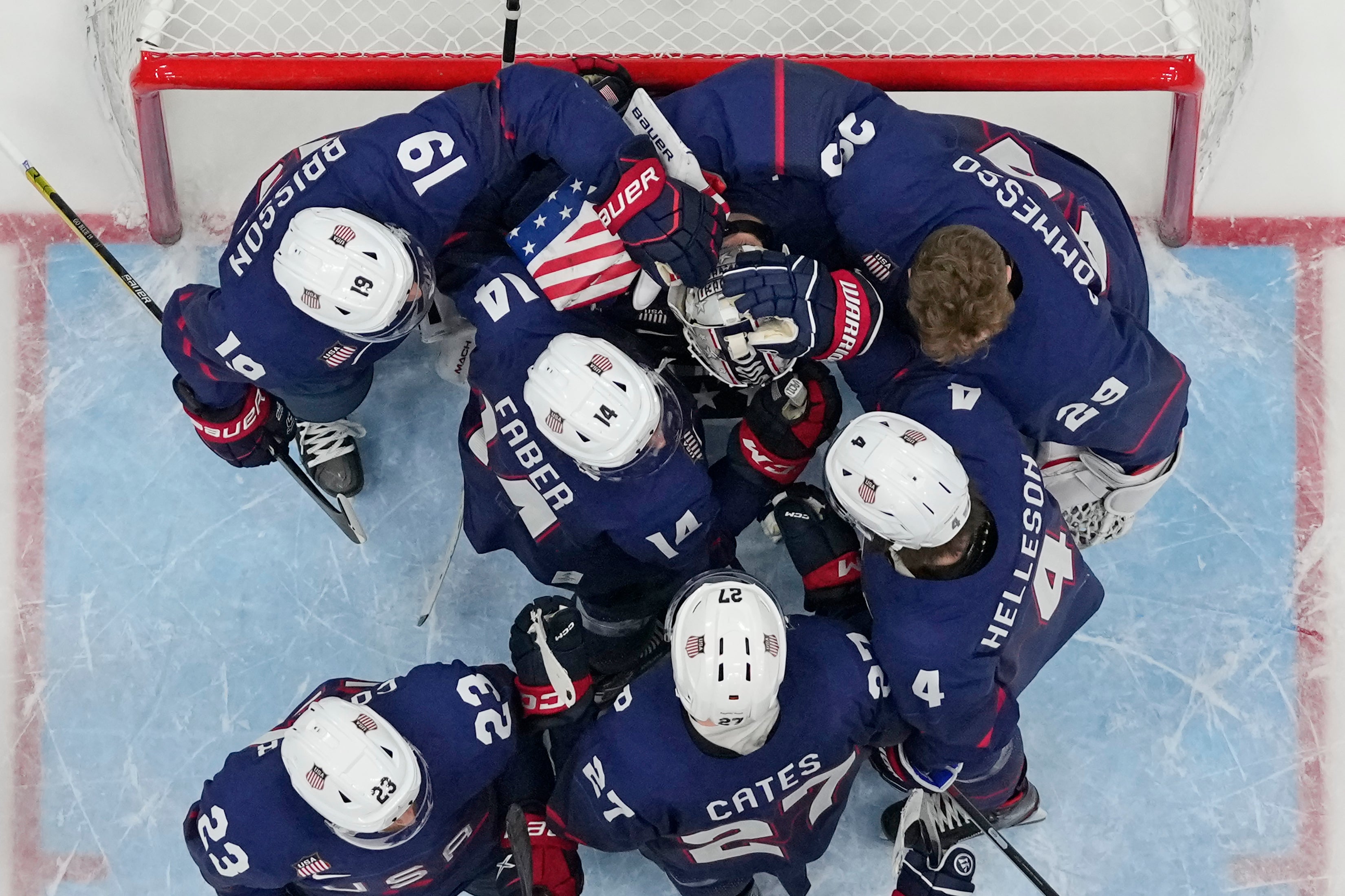 United States ice hockey players console goalkeeper Strauss Mann after their 3-2 shoot-out loss to Slovakia in the quarter-finals (Matt Slocum/AP)
