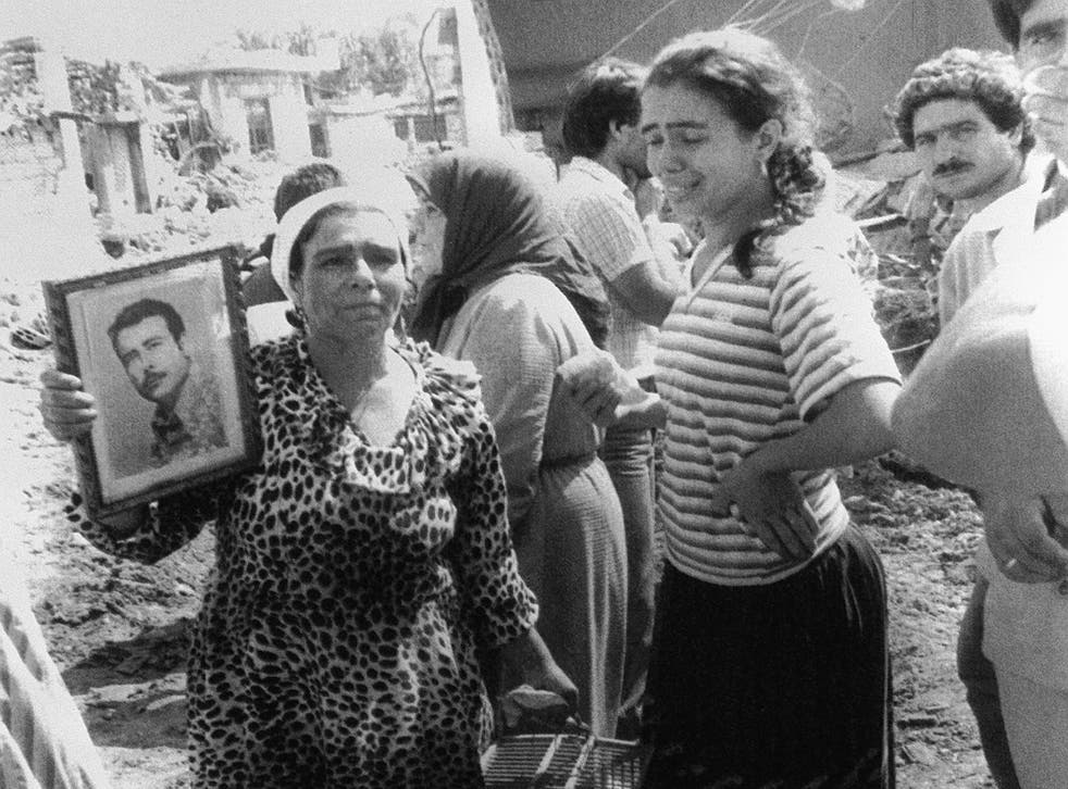 <p>A Palestinian woman holds up a portrait of her dead husband after the massacre in Sabra in 1982 </p>