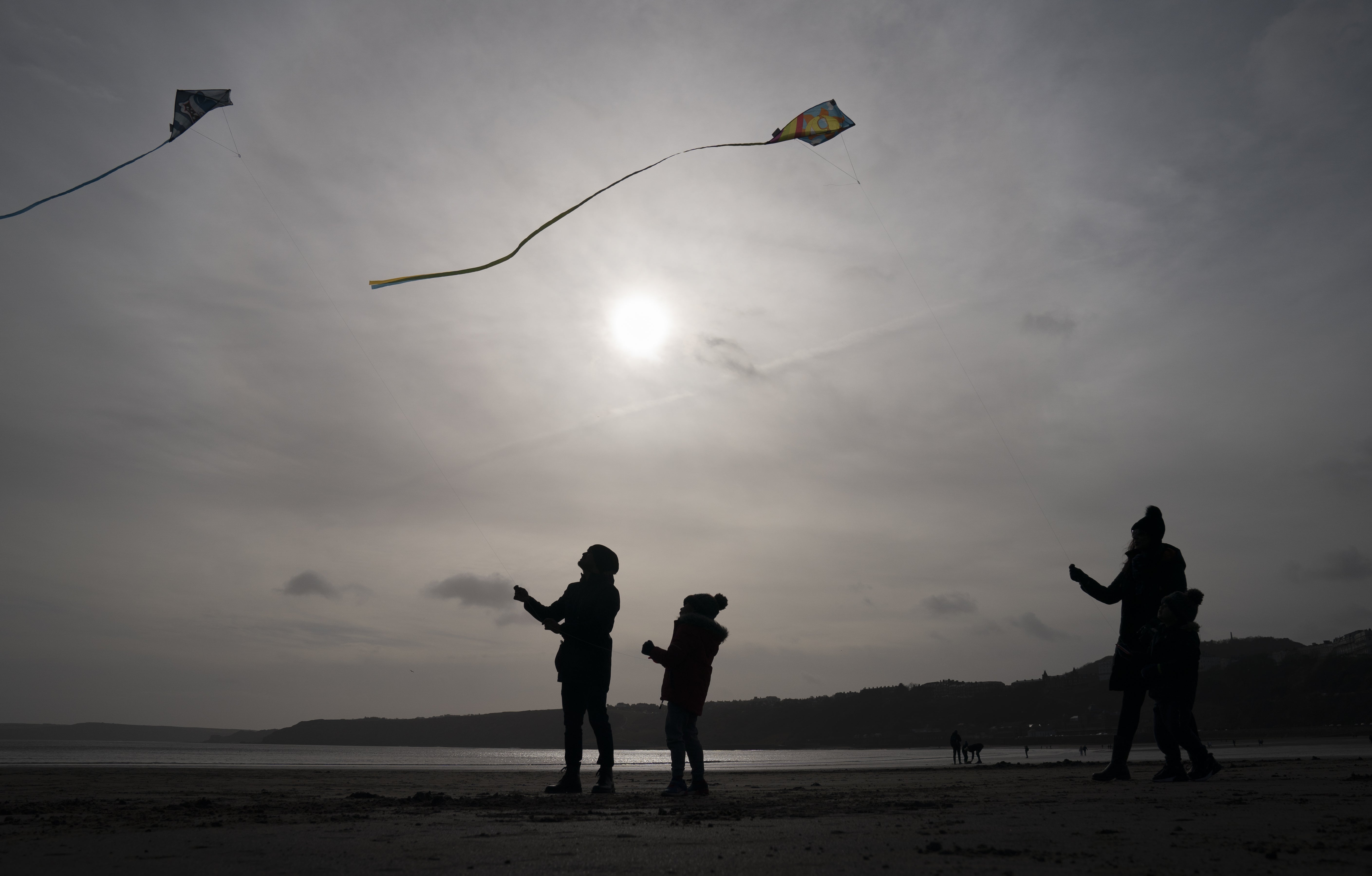 People fly kites on Scarborough beach in North Yorkshire (Danny Lawson/PA)