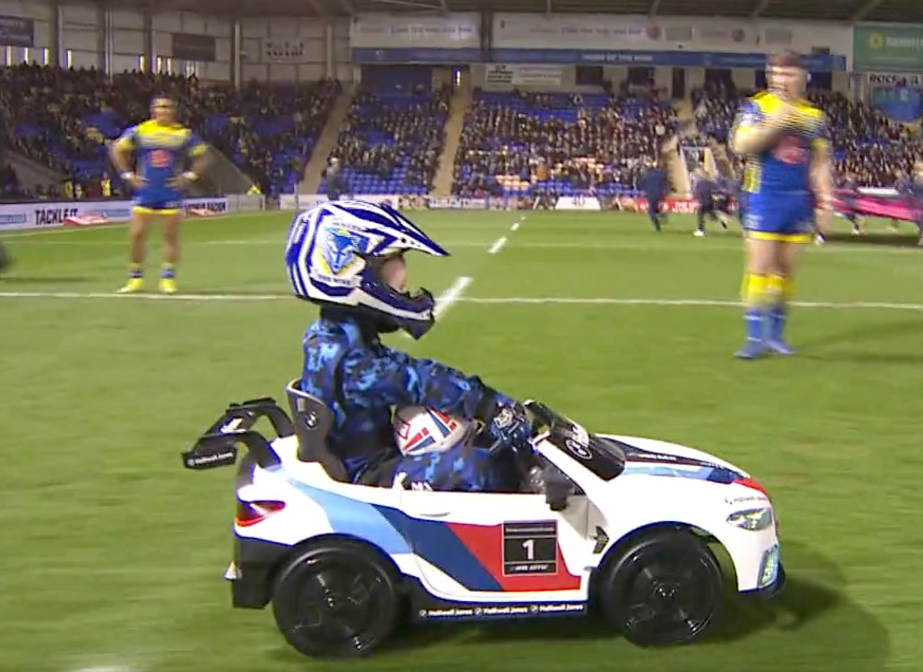A mascot drives the ball on to the field of play