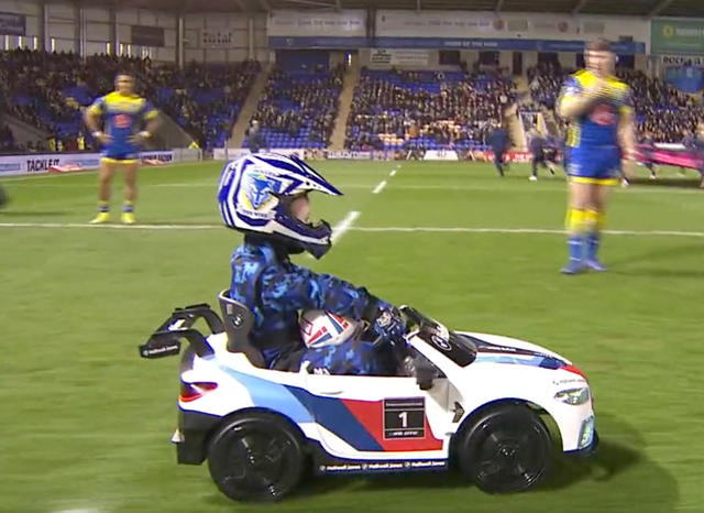 <p>A mascot drives the ball on to the field of play</p>