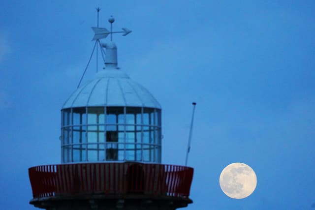 <p>The full moon known as the ‘snow moon’ rises above Howth lighthouse in Dublin, February 2022 (Brian Lawless/PA)</p>