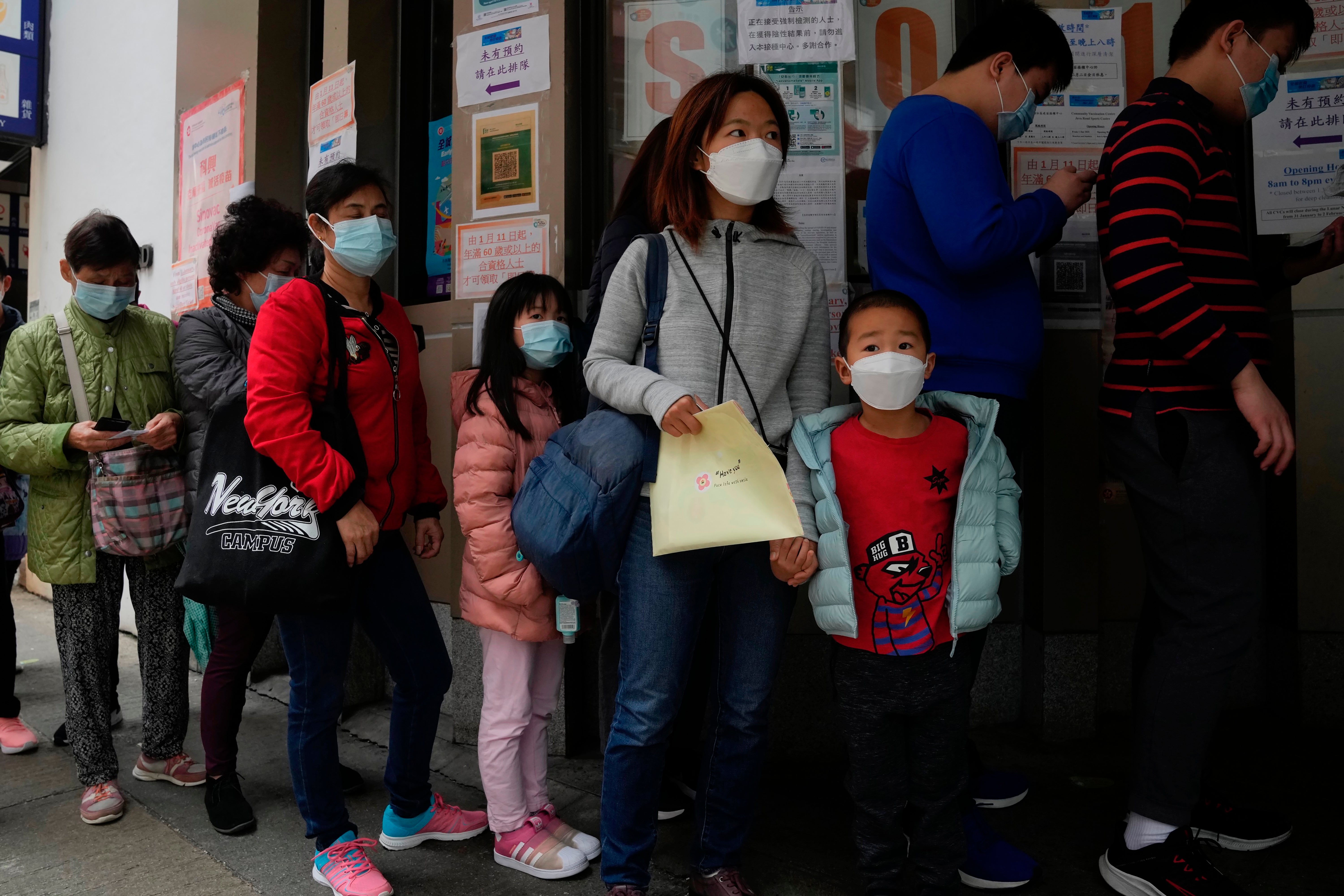 Children line up to receive China’s Sinovac Covid coronavirus vaccine at a community vaccination center in Hong Kong, 15 February 2022