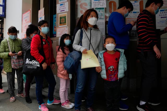 <p>Children line up to receive China’s Sinovac Covid coronavirus vaccine at a community vaccination center in Hong Kong, 15 February 2022</p>