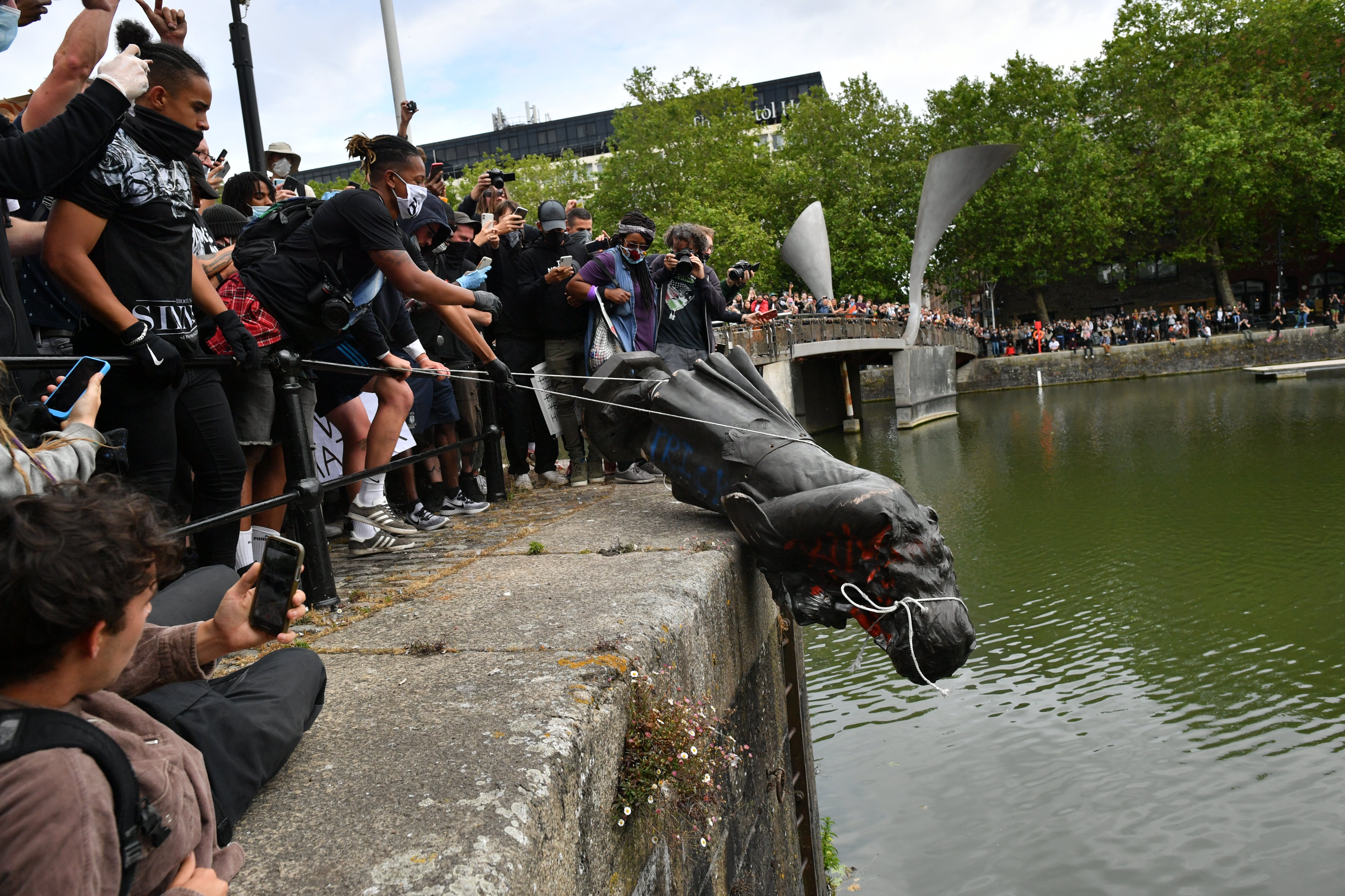 Protesters throwing a statue of Edward Colston into Bristol harbour during the Black Lives Matter protest rally