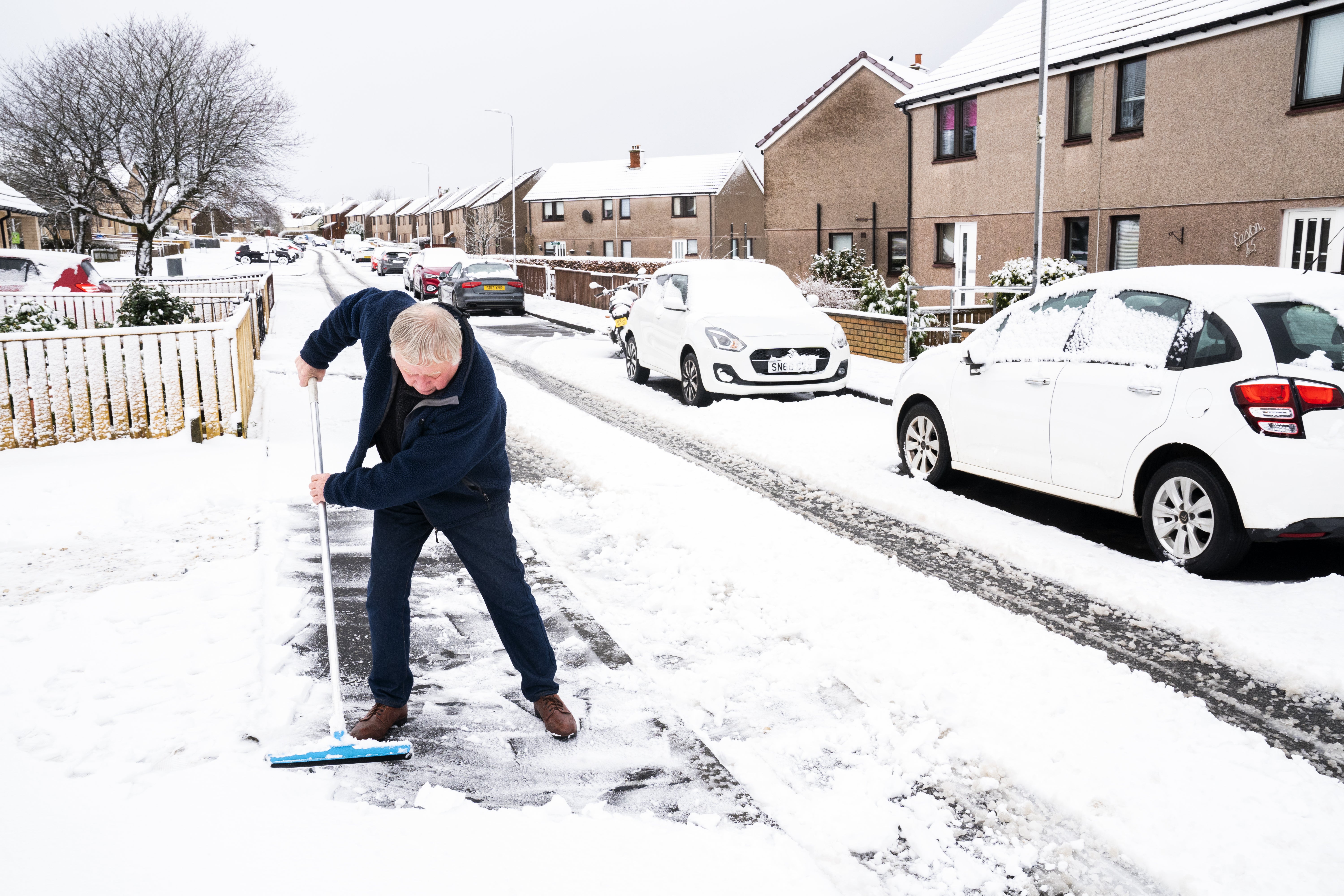 Residents clear snow from the street in California, near Falkirk in central Scotland (Jane Barlow/PA)