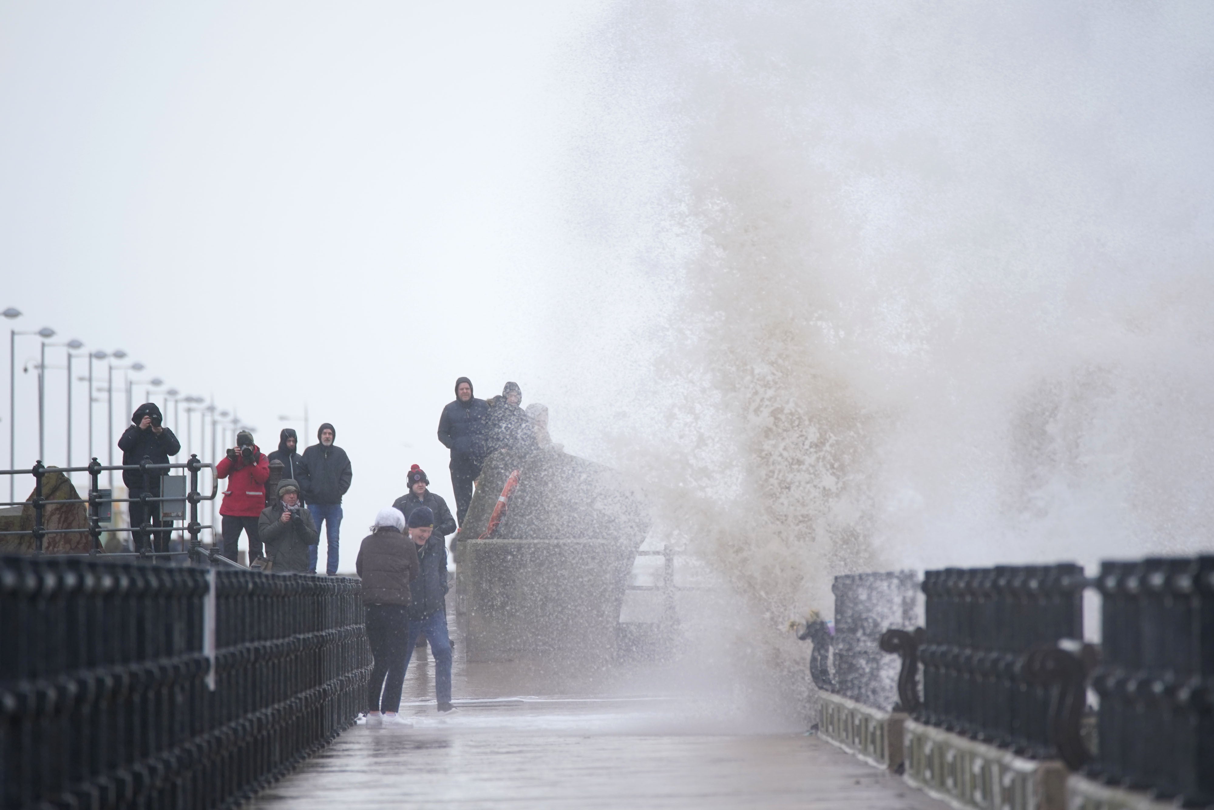 People look at the waves in New Brighton, Merseyside (Peter Byrne/PA)
