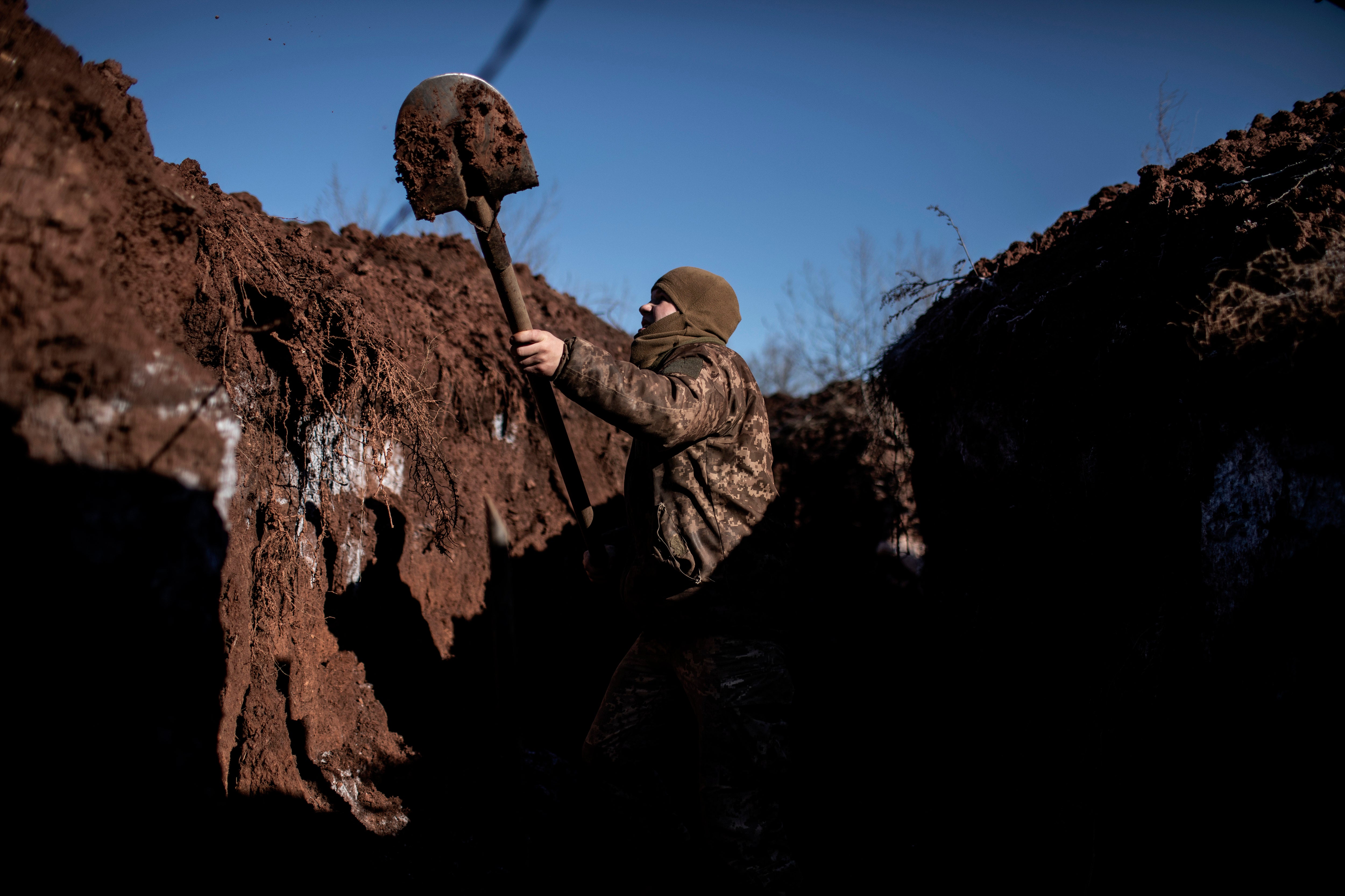 A Ukrainian serviceman digs a trench at his unit’s position at contact line near the village of Svitlodarsk, in Donestsk region
