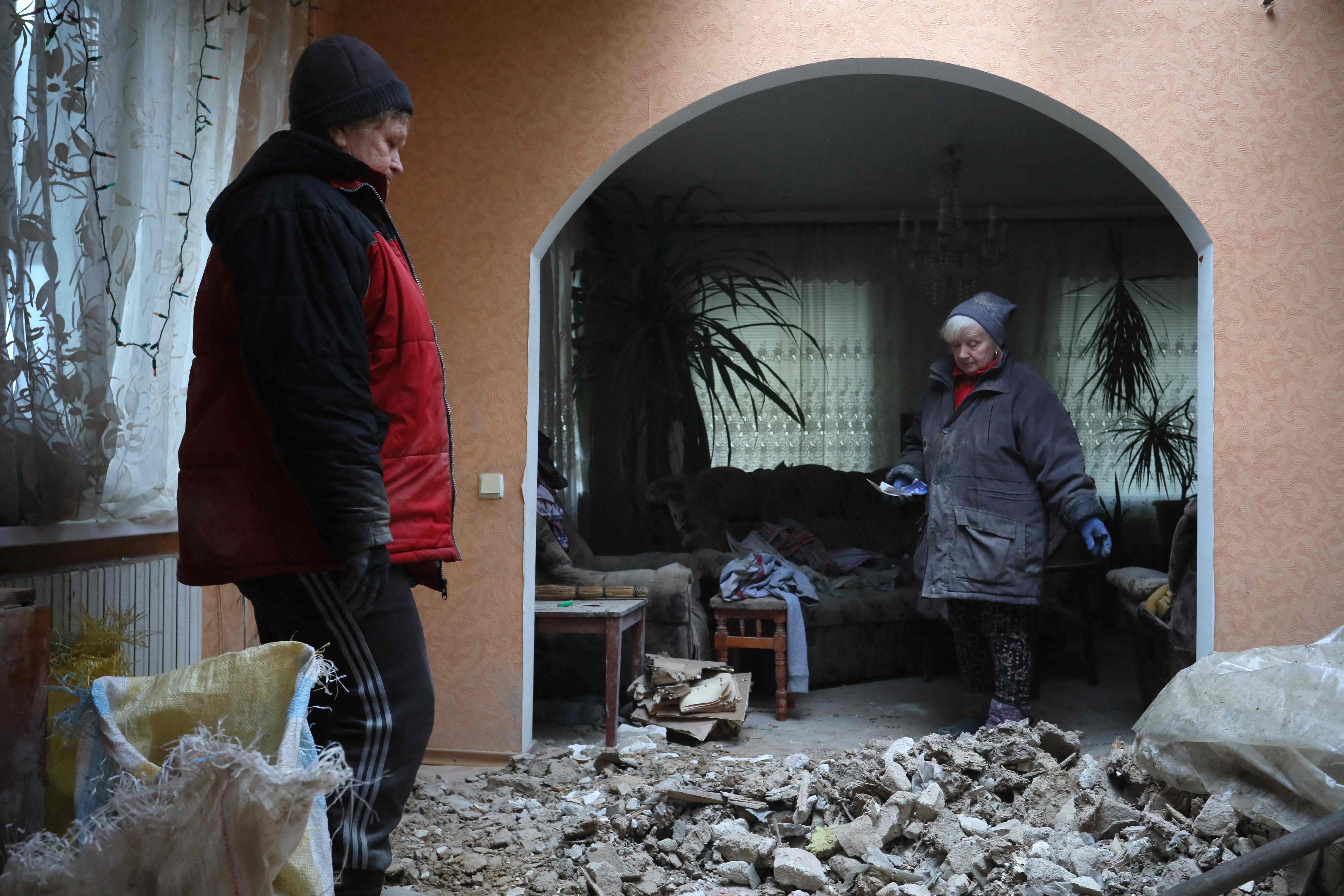 Local residents of the Ukrainian-controlled village of Stanytsia Luhanska, Luhansk region, clean up debris from homes after a shelling by Russia-Backed separatists on Friday