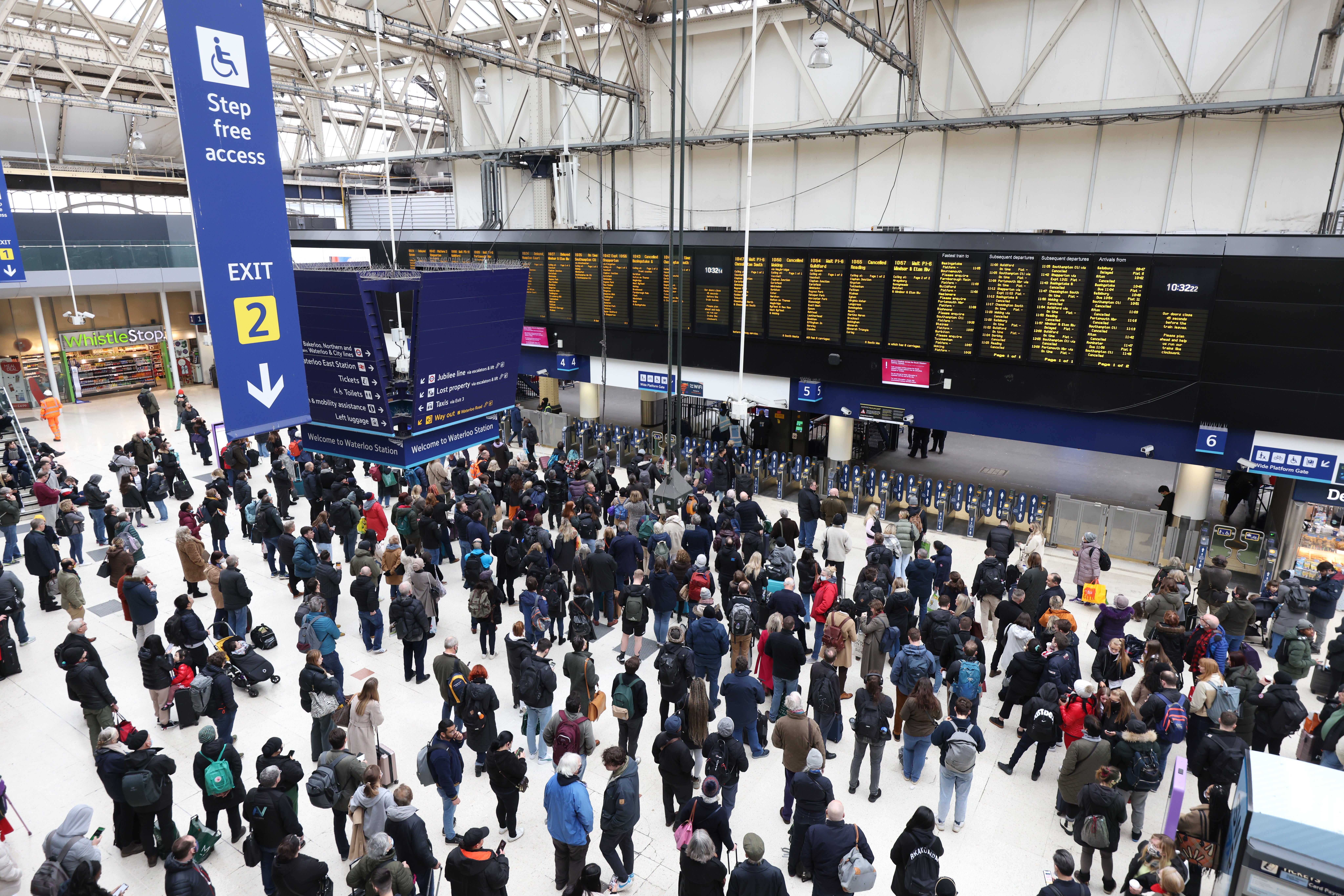 Passengers wait at Waterloo station, London, for cancelled or delayed trains in the aftermath of Storm Eunice (James Manning/PA)