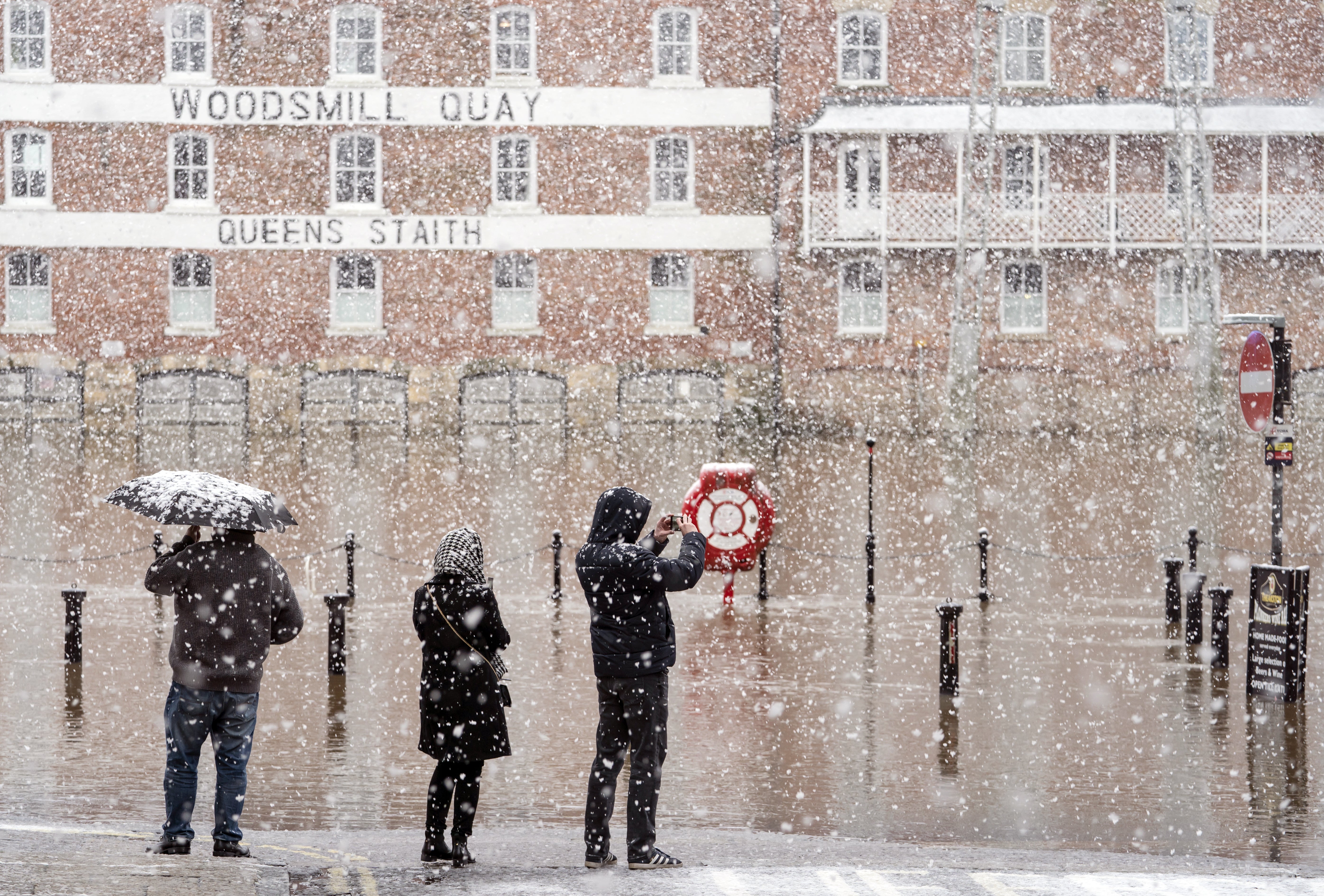 People look at flood water amid the heavy flurries in York