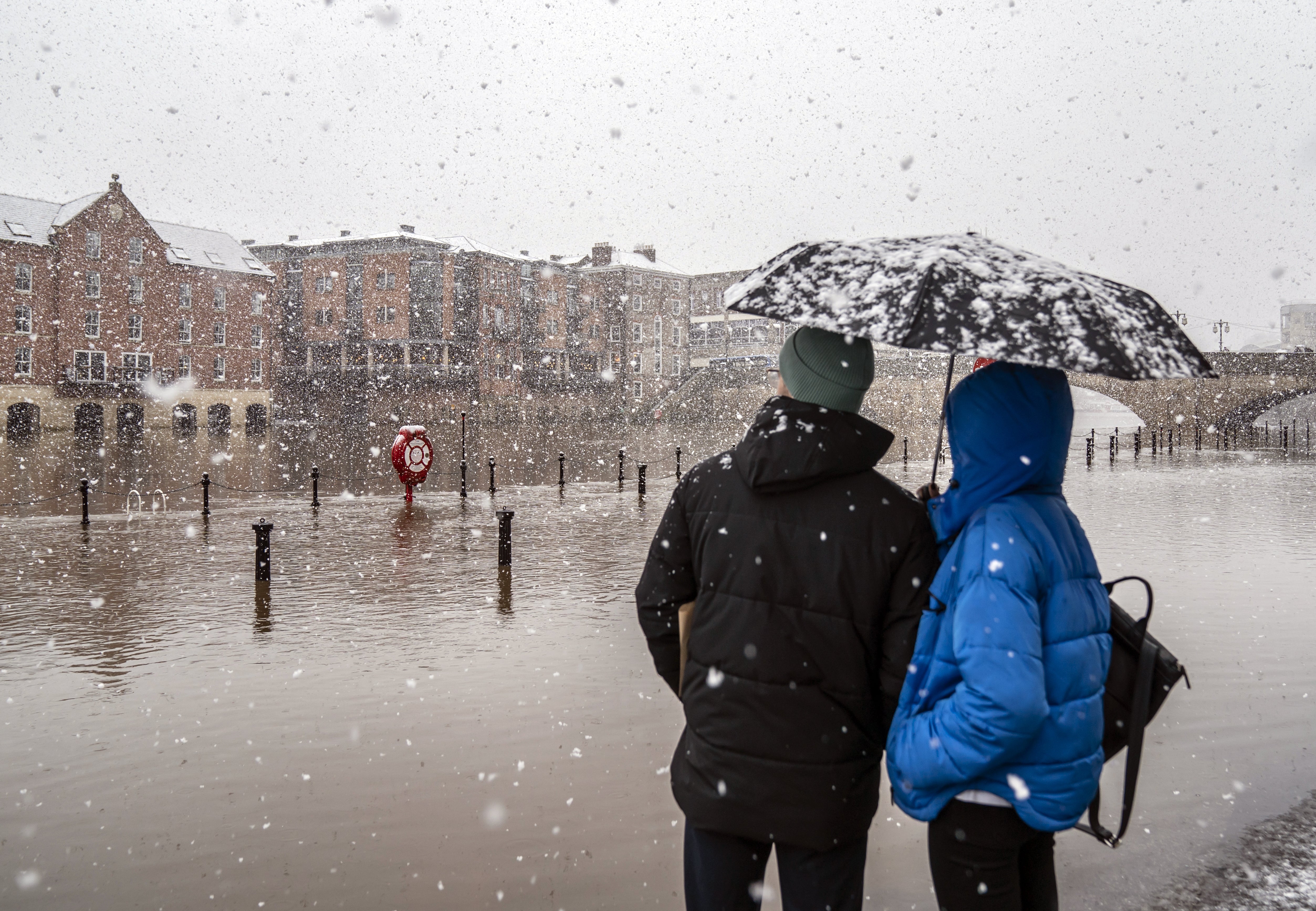 People observe flood water in heavy snow in York city centre (Danny Lawson/PA)